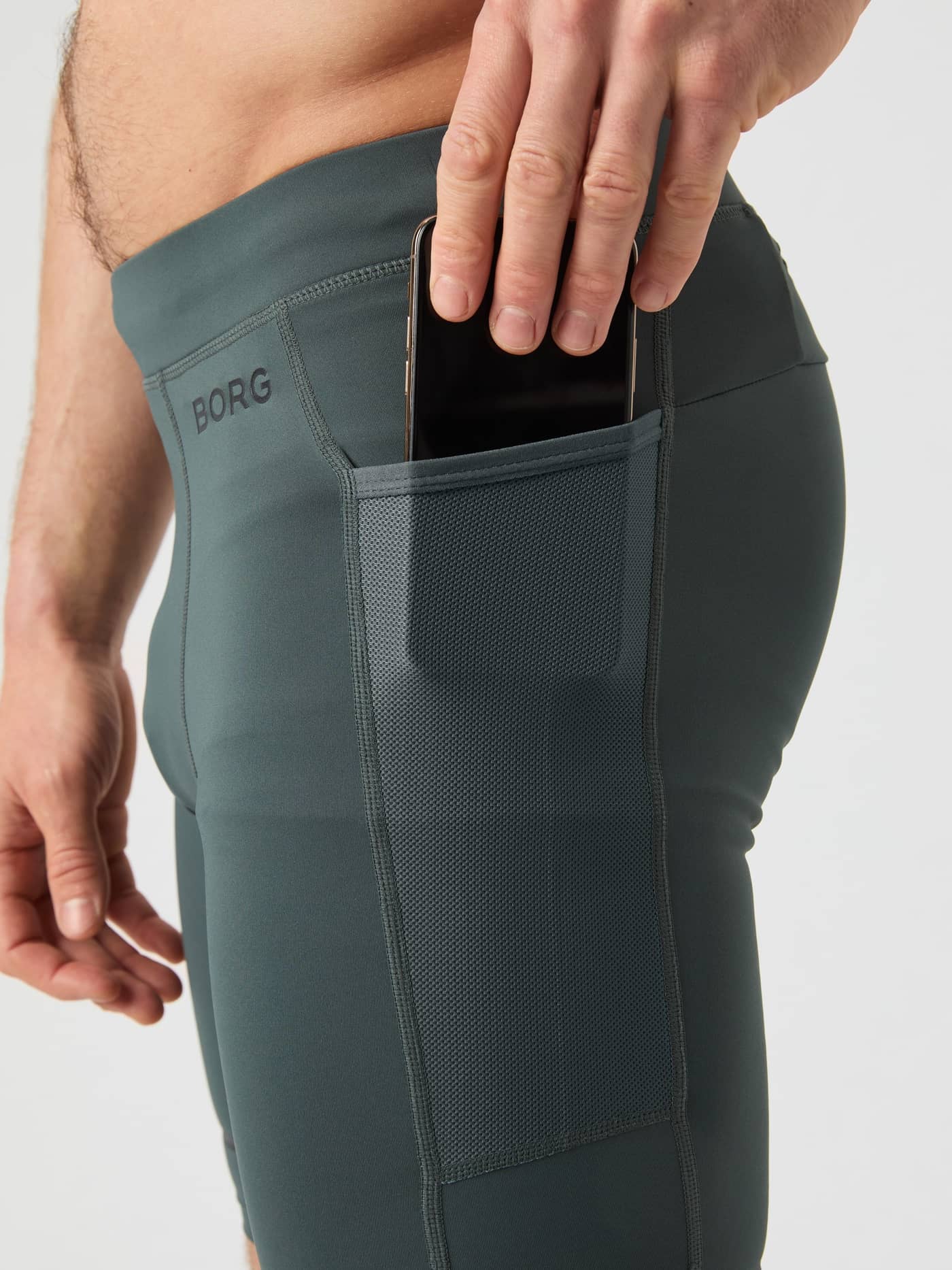 Close-up van de Borg Running Short Tights in Urban Chic (Groen) met een mesh zijzak voor hardloopprestaties. - Image 4
