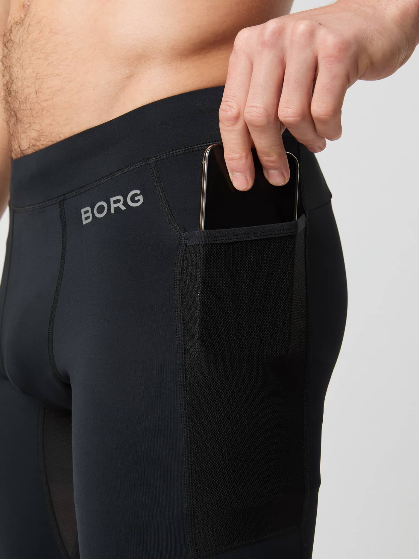 Close-up van Borg Running Short Tights in Black Beauty (Zwart) met grijs logo en een mesh zijzak voor een telefoon. - Image 4