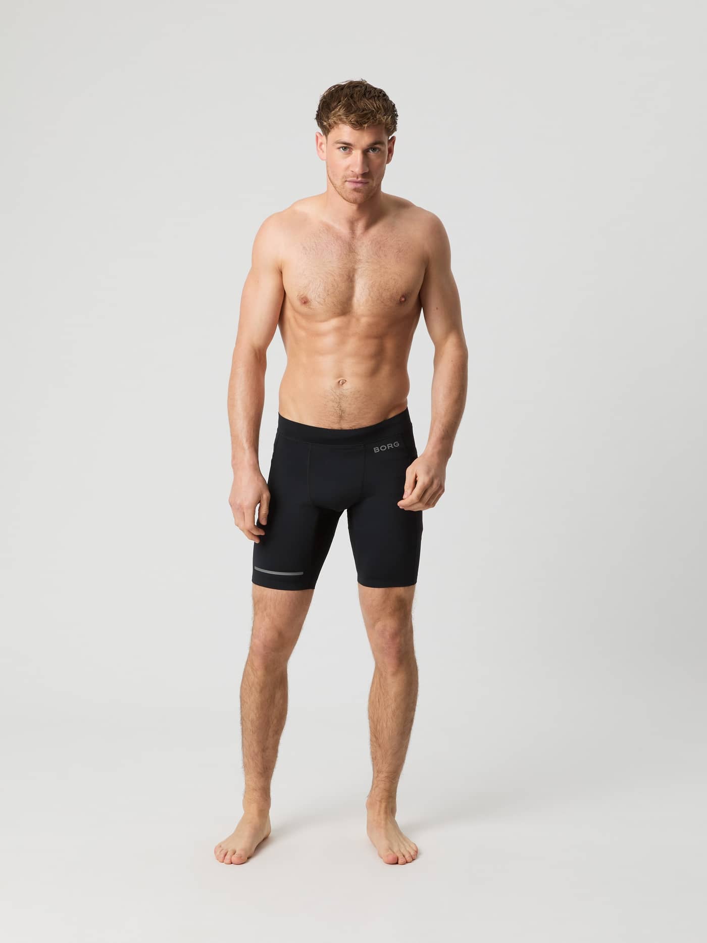 Man in de Borg Running Short Tights in Black Beauty (Zwart) met grijs logo in vooraanzicht, ideaal voor runningprestaties. - Image 3