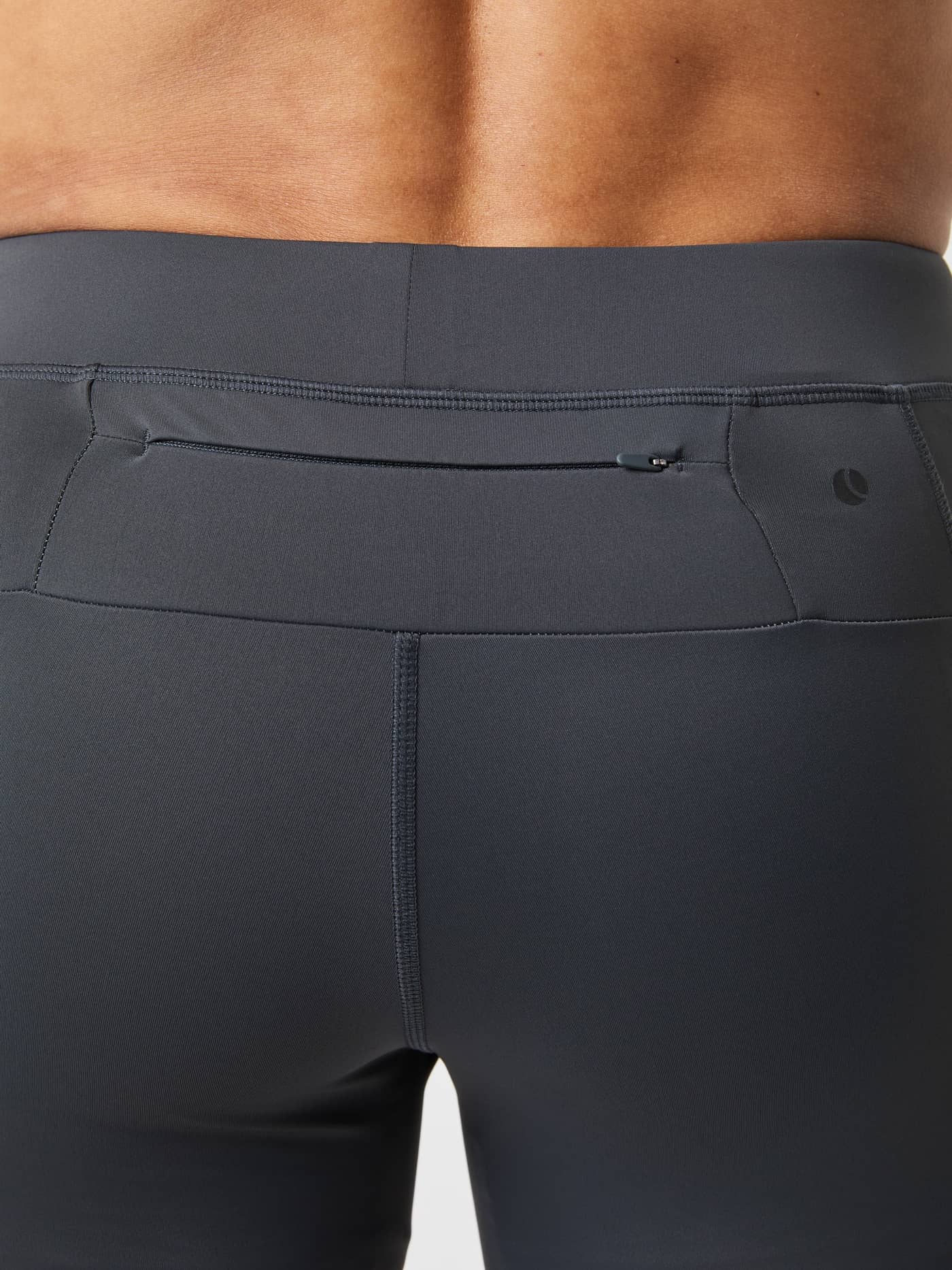 Close-up back view of the Borg Running Short Tights in Asphalt (Grey), highlighting the functional zip key pocket. - Image 6