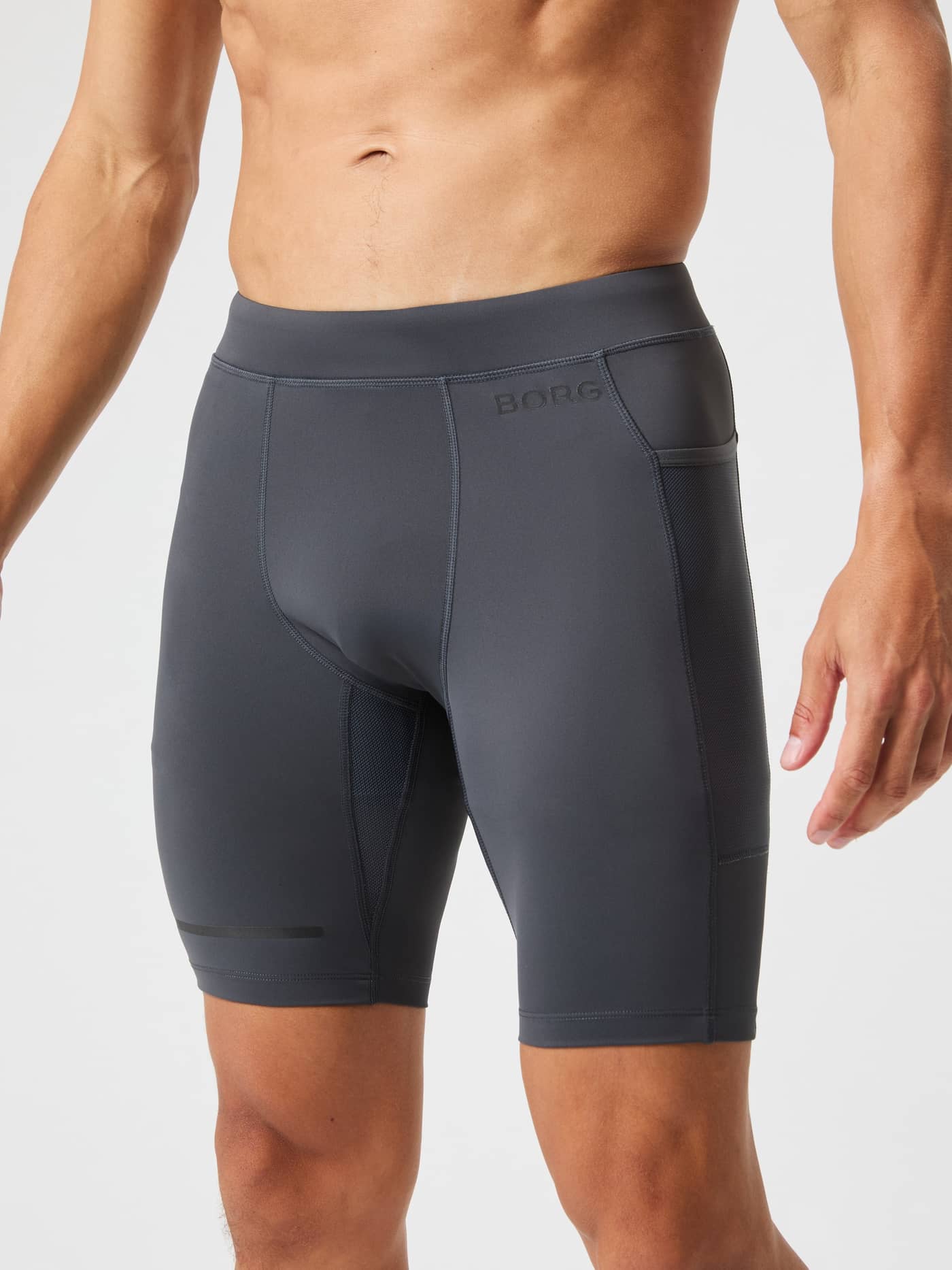 Front view of a man wearing the Björn Borg Running Short Tights in Asphalt (Grey) with functional mesh side pockets. - Image 2
