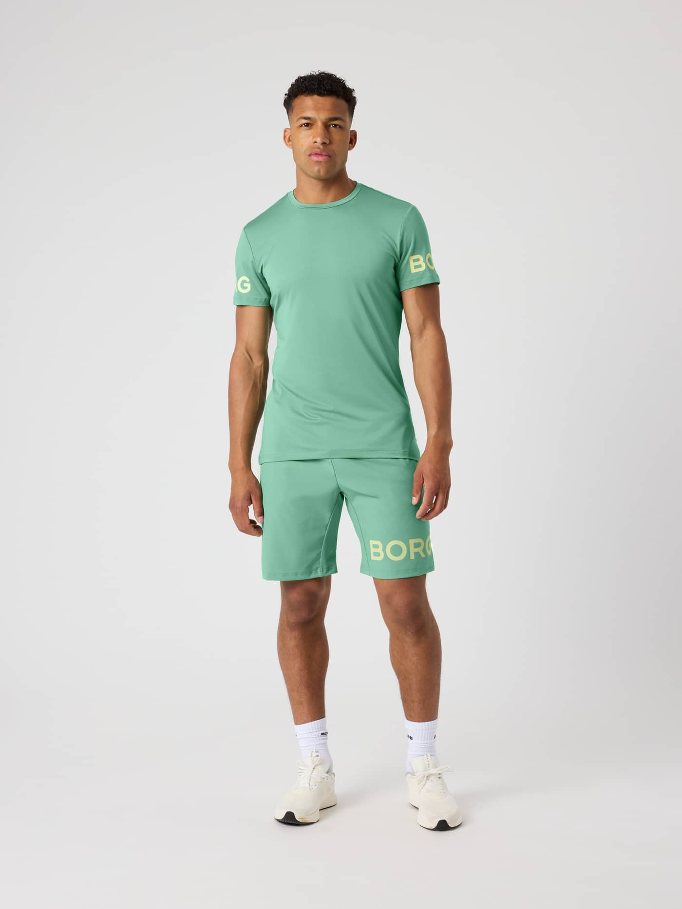 Borg Shorts 9 Inch i Malachite Green (Grøn) set forfra med et gult perforeret logo til træning. - Image 3