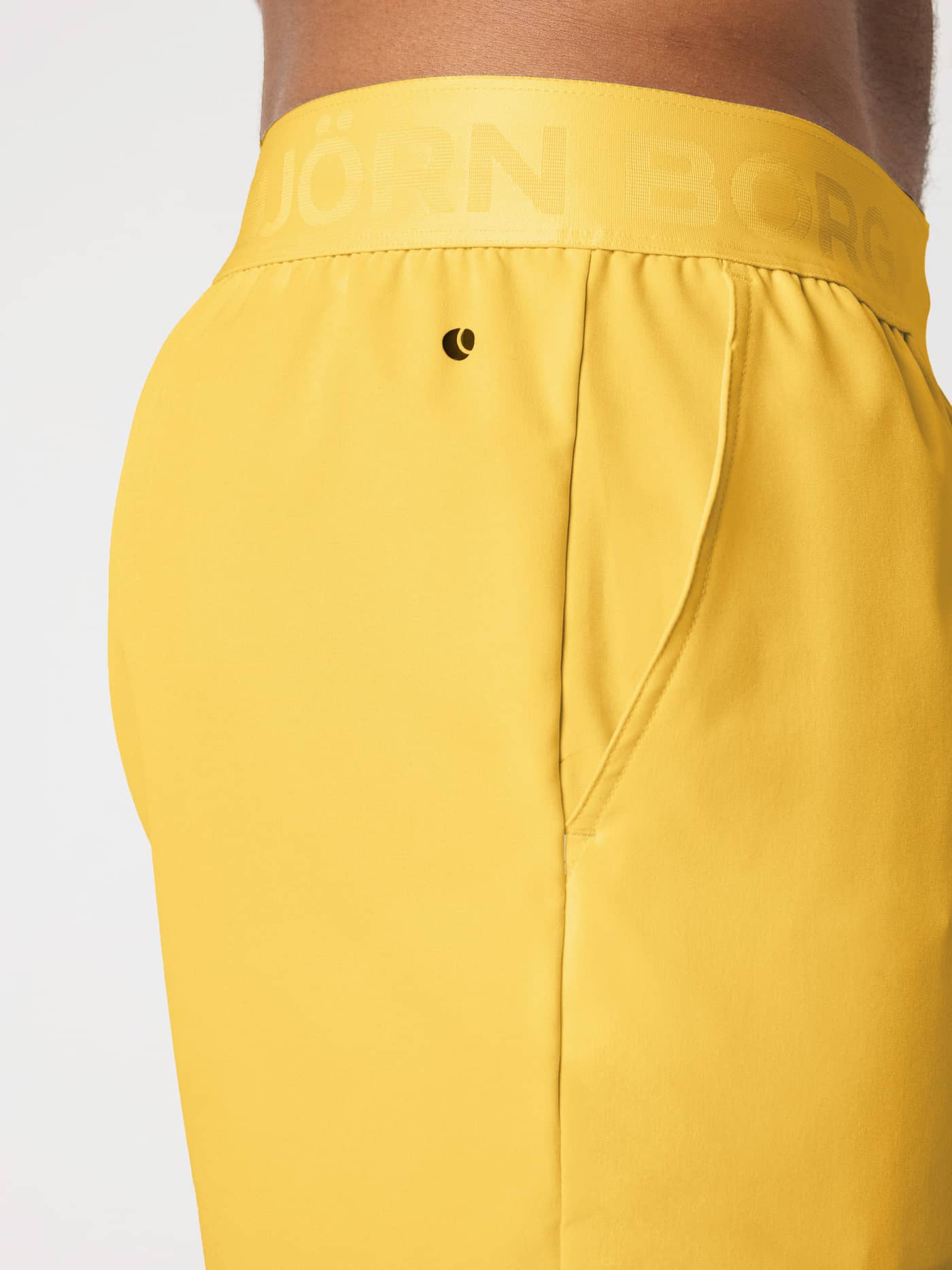 Close-up side view of Borg Shorts 9 Inch in Citrus (Orange) with a tonal Citrus branded elastic waistband for training. - Image 4