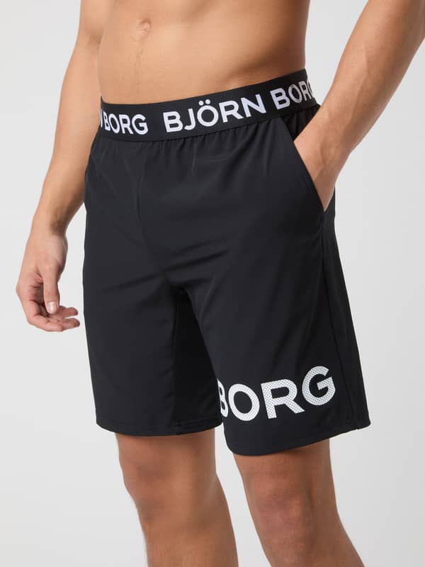 Front close-up of a model wearing the black Borg 9" Shorts with the classic logo waistband and large Borg print on the leg.