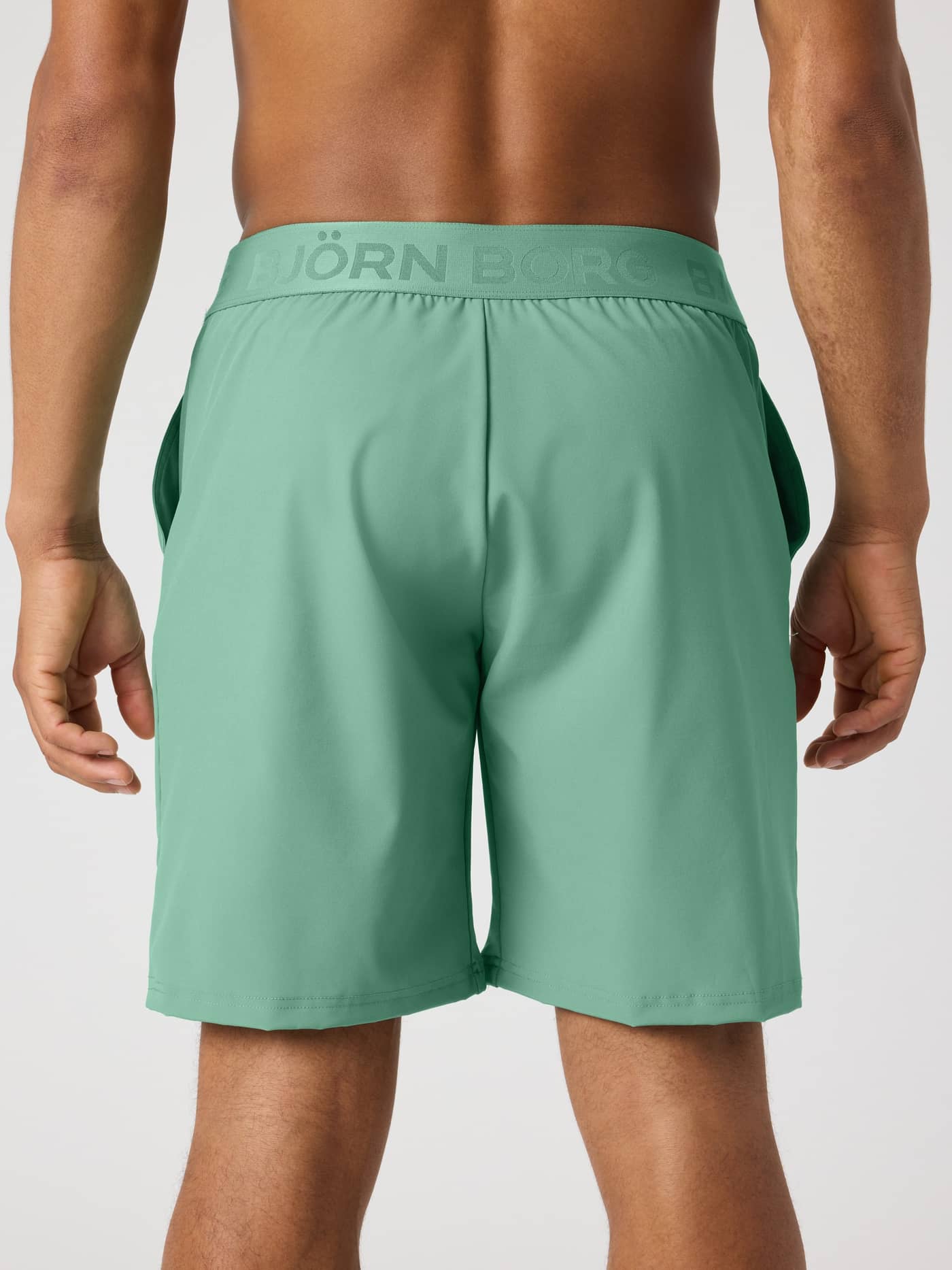 Borg Shorts 9 Inch i Malachite Green (Grøn) set bagfra på en mand til træning med en grøn logo-linning. - Image 2