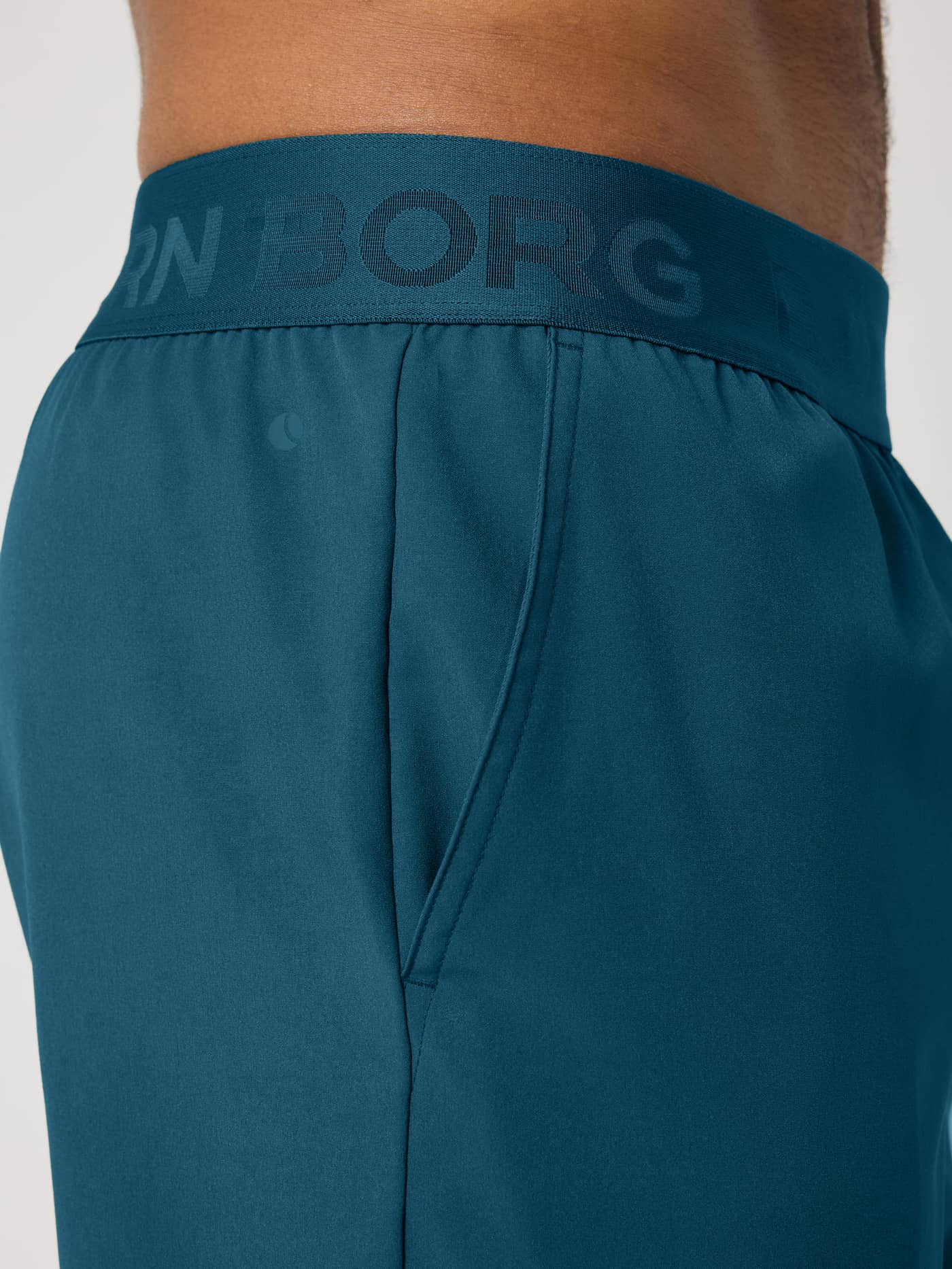 Close-up of the training Borg Shorts 9 Inch in Reflecting Pond (Green) with a tonal logo waistband and side pocket. - Image 4