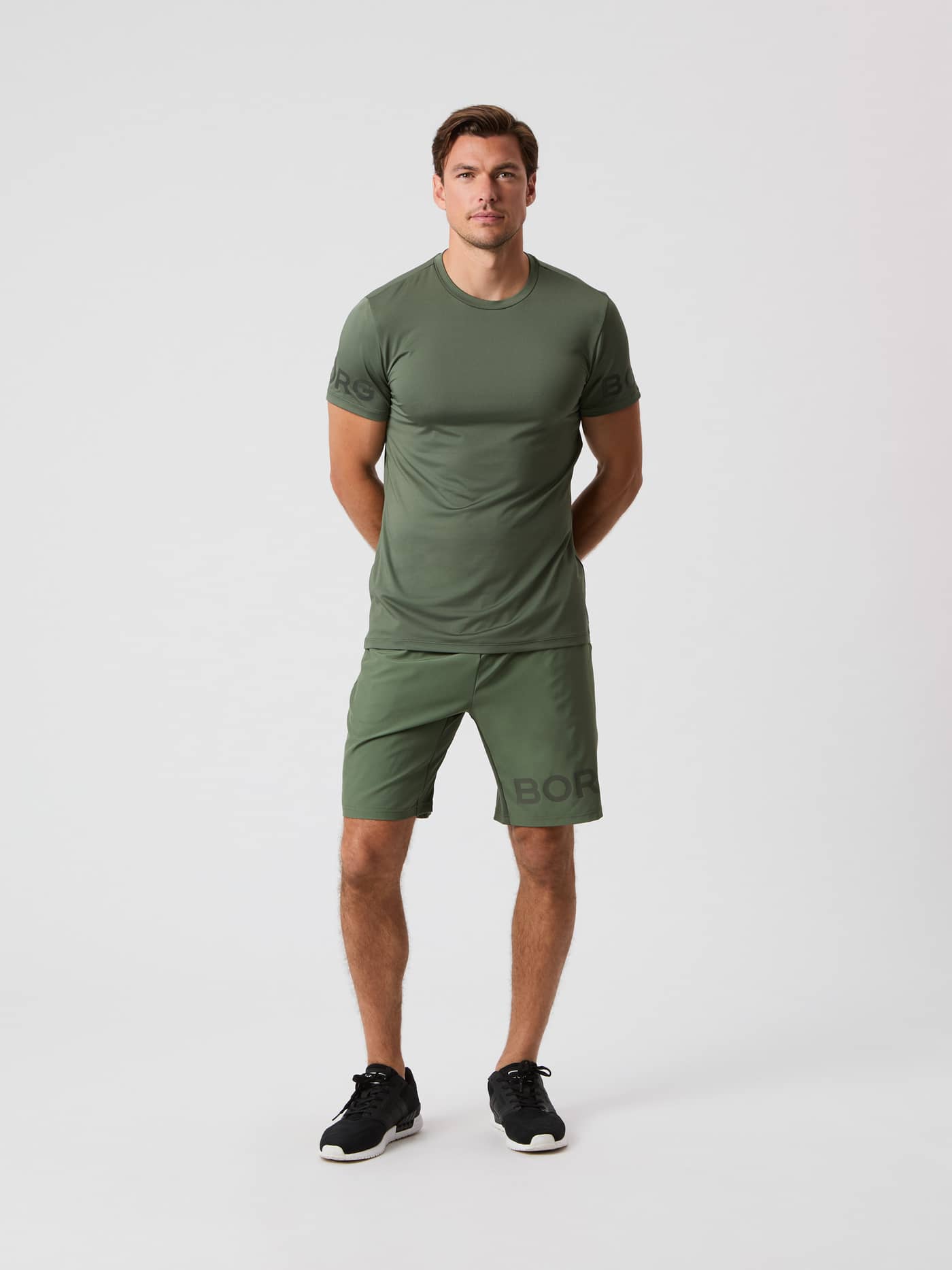Front view of a male model wearing the thyme green Björn Borg 9" Shorts with a matching t-shirt. - Image 3