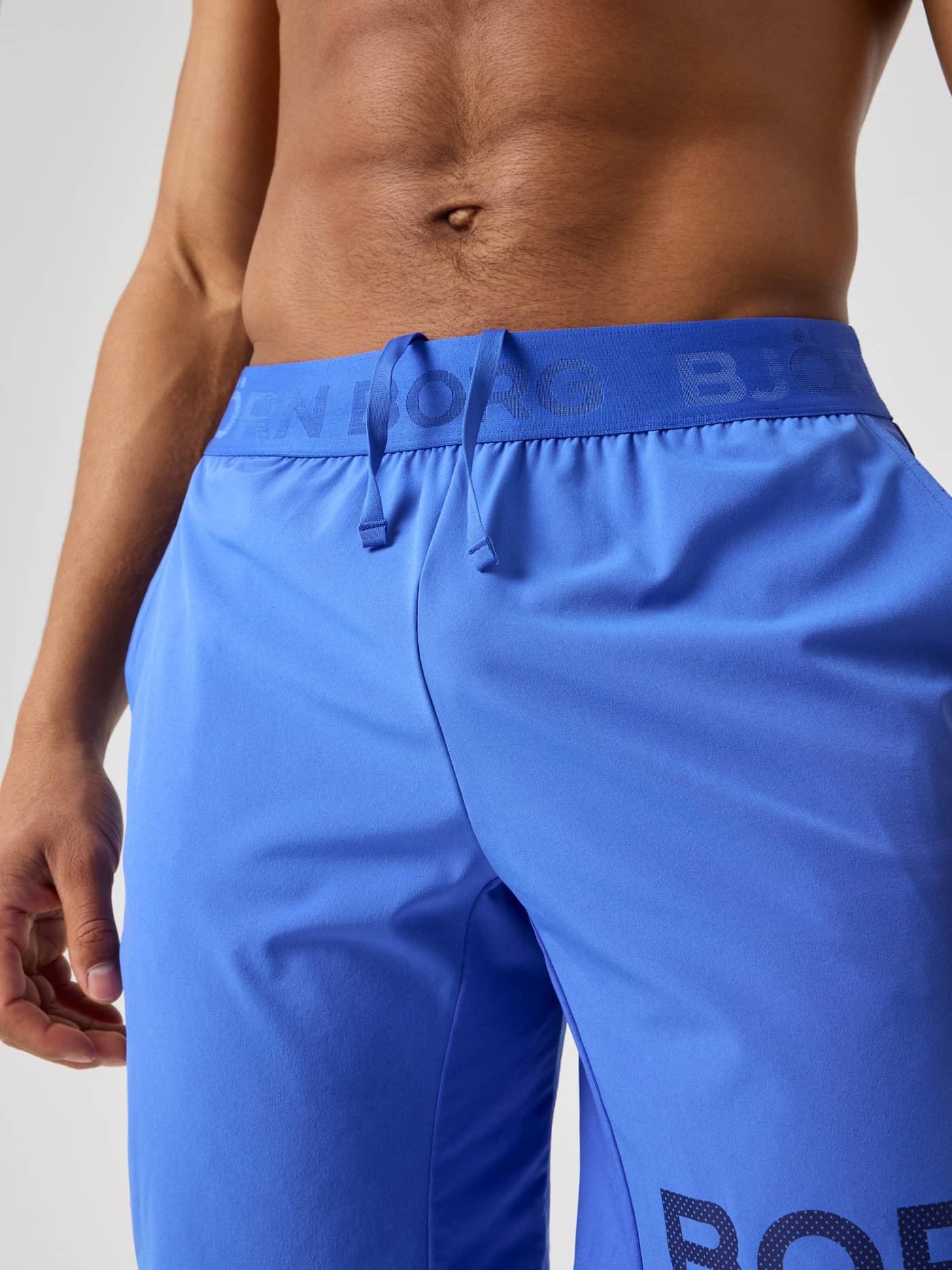 Amparo Blue (Blue) Borg Shorts 9 Inch on a man, showing the tonal blue logo waistband and performance training fabric. - Image 5