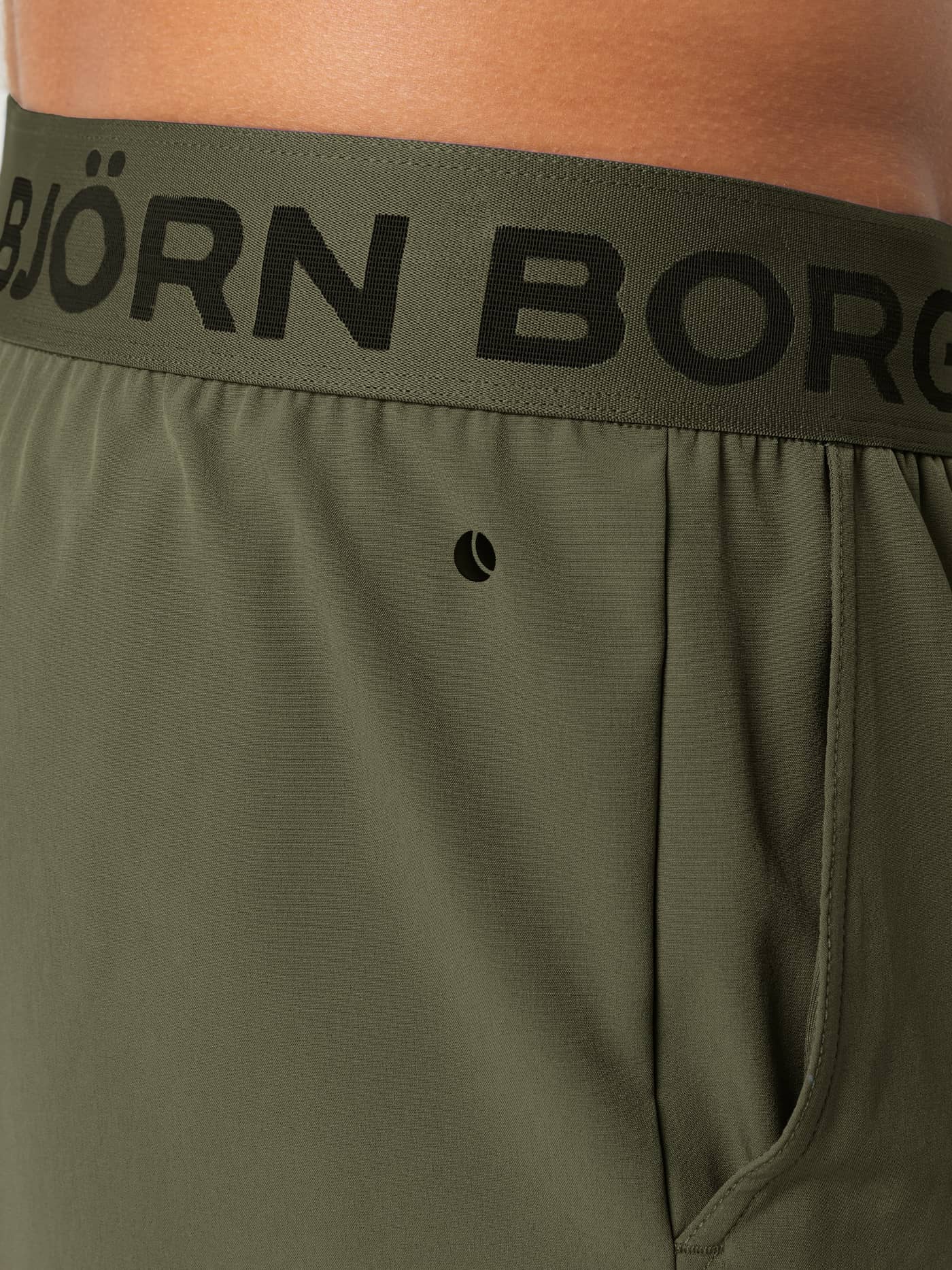 Nærbillede af den elastiske logo-linning på Borg Shorts 9 Inch i Forest Night (Grøn) til træning. - Image 5