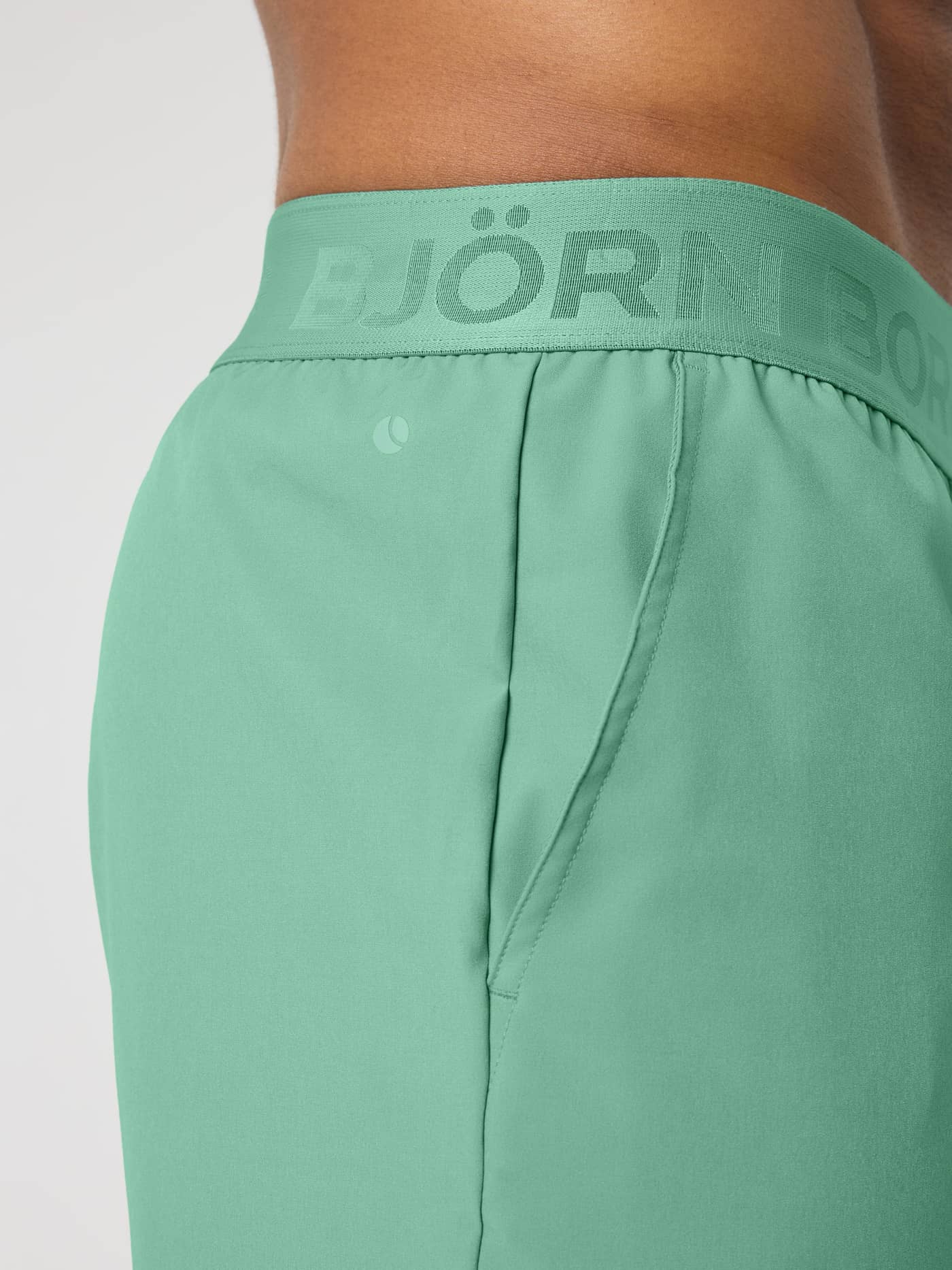 Borg Shorts 9 Inch i Malachite Green (Grøn) set tæt på med logo-elastik og tennisbold-print til træning og tennis. - Image 6