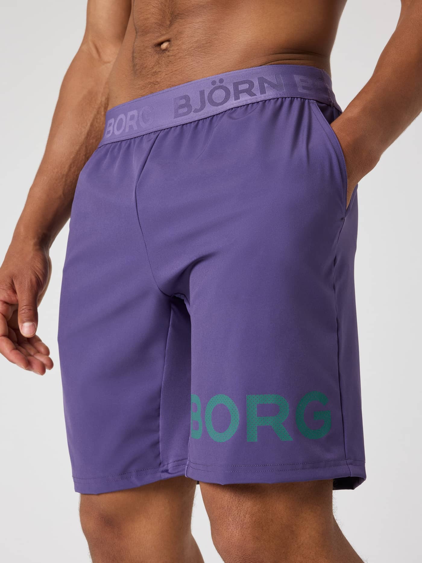 Närbild framifrån på Borg Shorts 9 Inch i Mystical (Lila) med en grön logotyp för gymträning. - Image 3