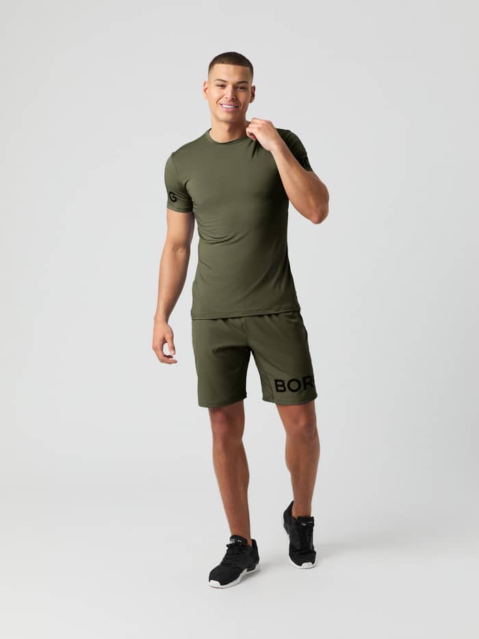 Full body shot of a man wearing the Björn Borg Borg 9" Shorts in forest green with a matching short-sleeved t-shirt.