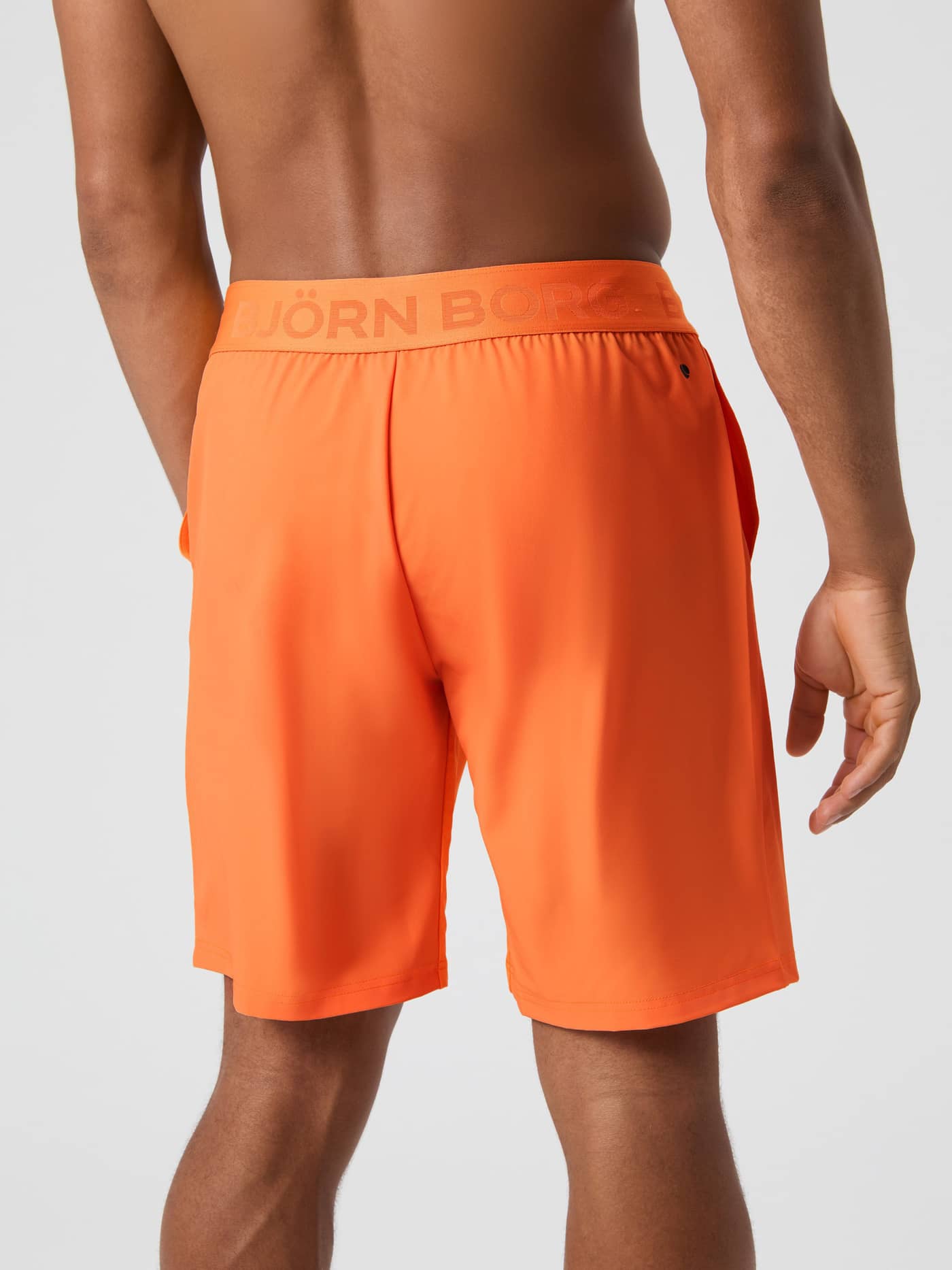 Bakside av mann i Shocking Orange (Oransje) Borg Shorts 9 Inch med ton-i-ton logo til tennis og trening. - Image 2