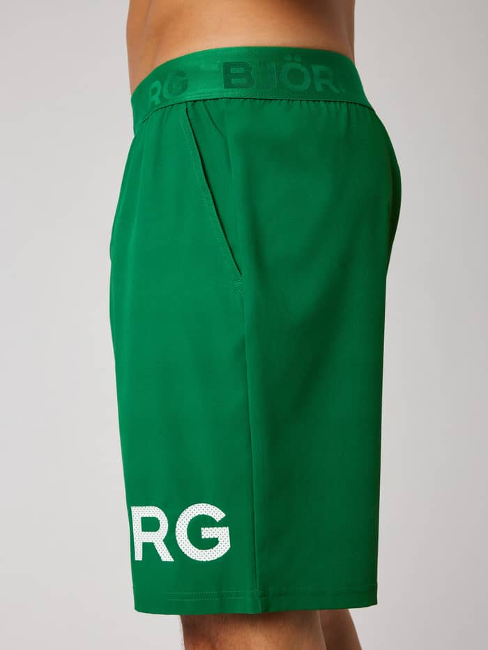 Side view of the Borg Shorts 9 Inch in Jolly Green (Green) for training, featuring side pockets and a white logo print.