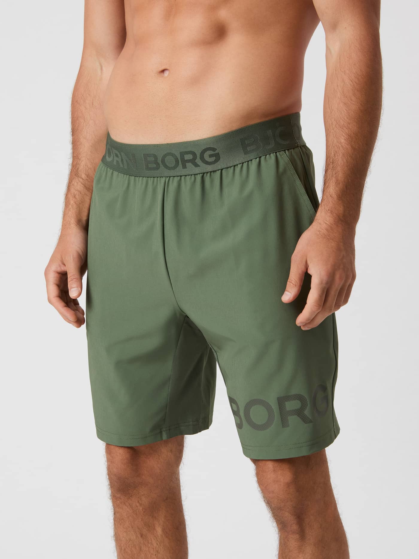 Front-side view of a model wearing the thyme green Björn Borg 9" Shorts. - Image 1