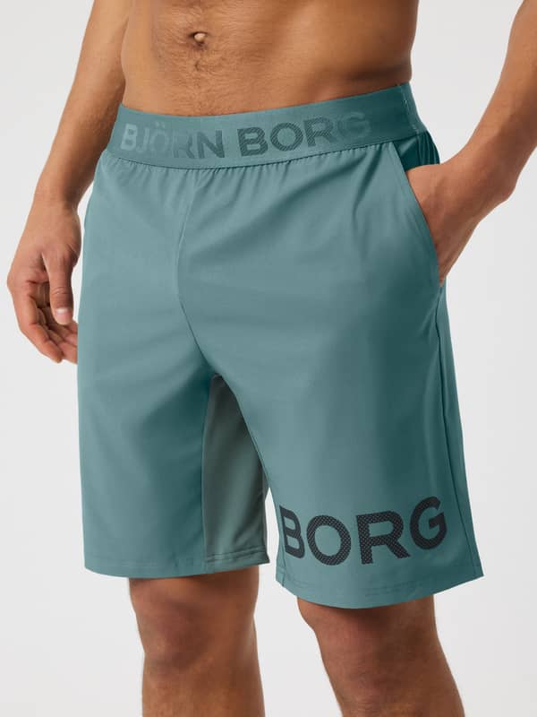 Front view of the training Borg Shorts 9 Inch in Balsam Green (Green) with a logo waistband and dark perforated logo.