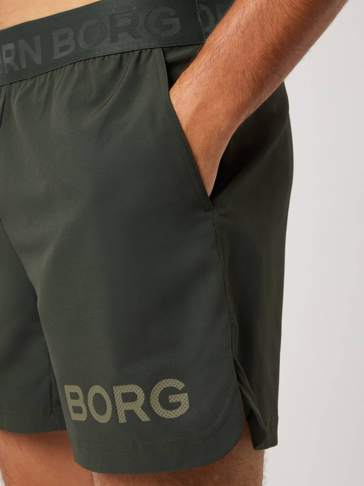 Borg Shorts 6 Inch in Rosin (Green) featuring a branded waistband, side pocket, and leg logo for technical training. - Image 4