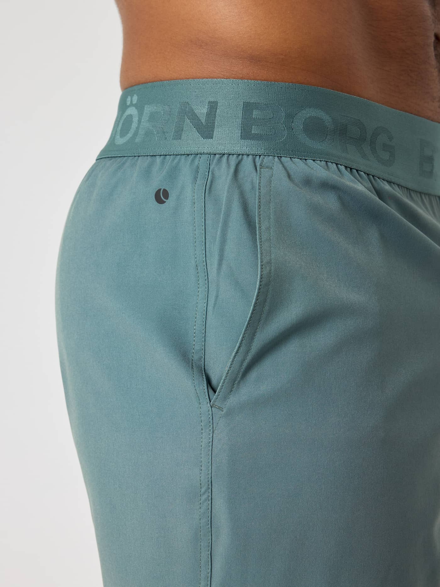 Side view of the Borg Shorts 6 Inch in Balsam Green (Green) showing the branded waistband and tennis logo for training. - Image 4