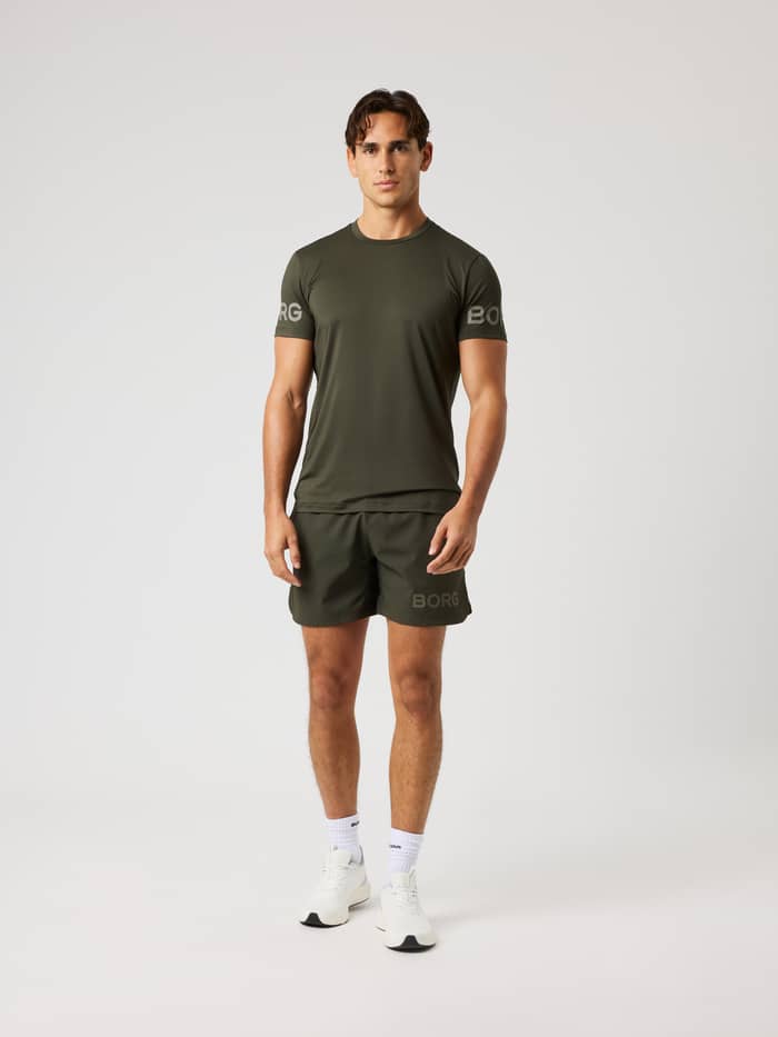 Vue de face d'un modèle en Borg Shorts 6 Inch en Rosin (Vert) avec un logo gris pour le training. - Image 3