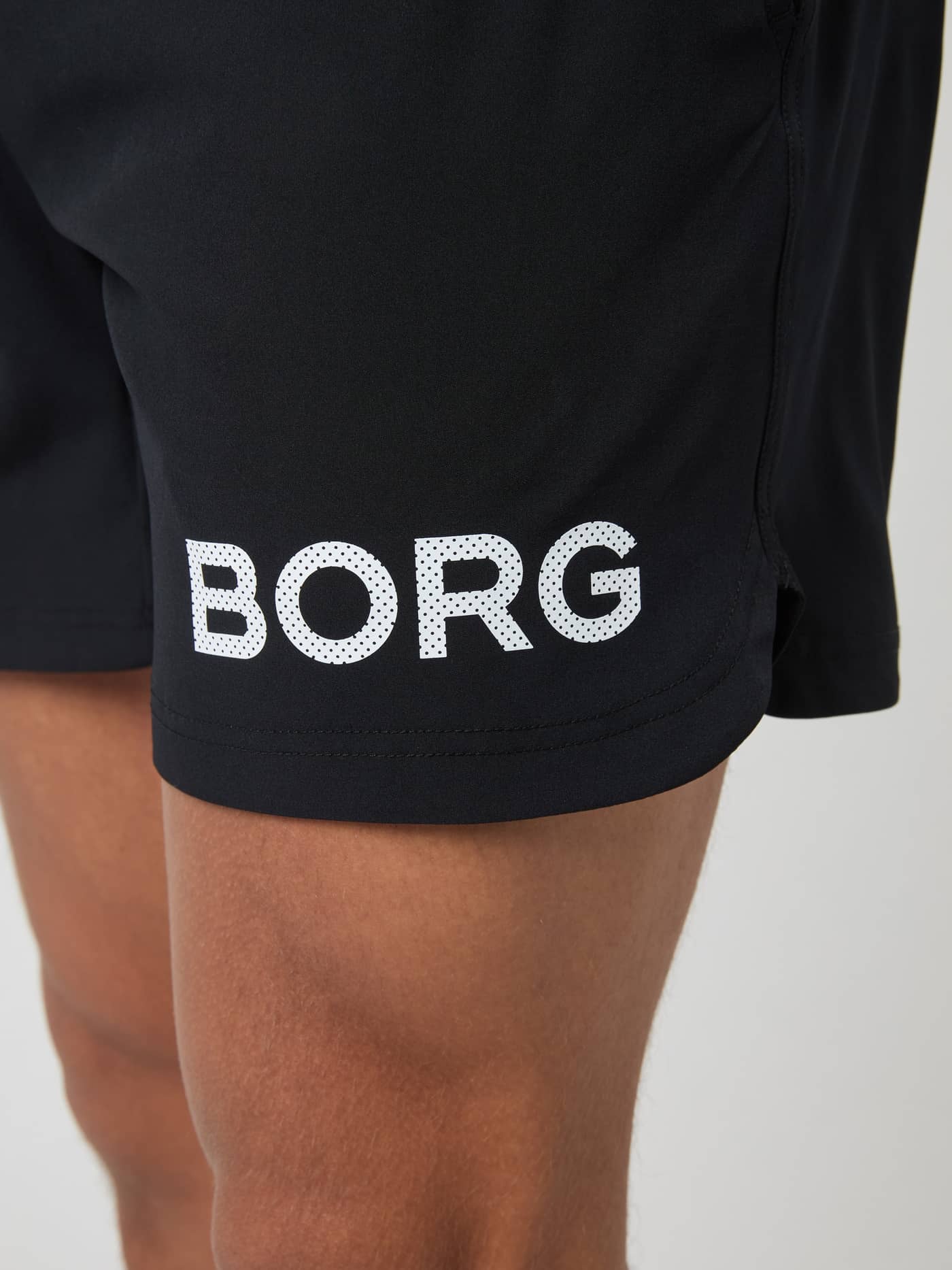 Gros plan du logo blanc imprimé sur la jambe du Borg Shorts 6 Inch en Black Beauty (Noir) pour l'entraînement. - Image 3