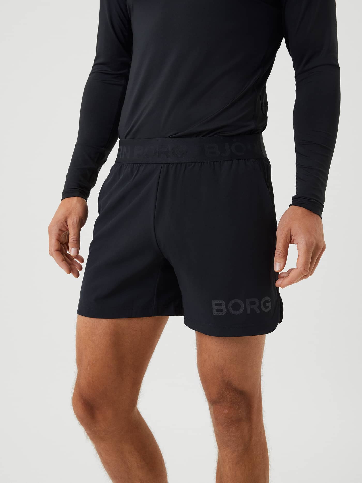 Close-up of a model wearing the black Borg 6" Shorts, showing the fit, branded waistband and logo detail on the leg. - Image 2