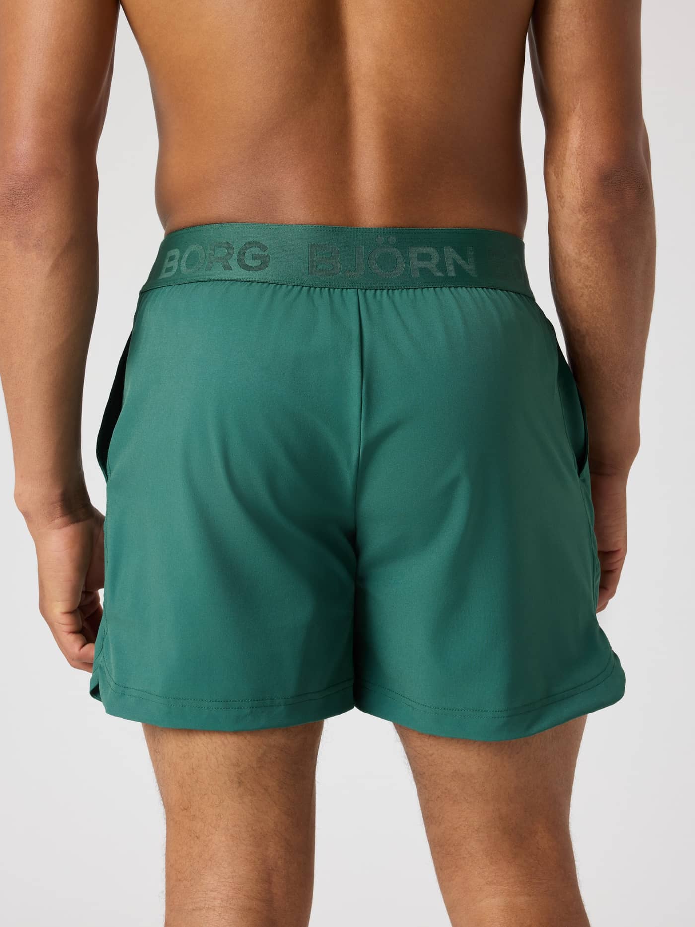 Back view of a man wearing Mallard Green (Green) Borg Shorts 6 Inch for performance training with a branded waistband. - Image 2