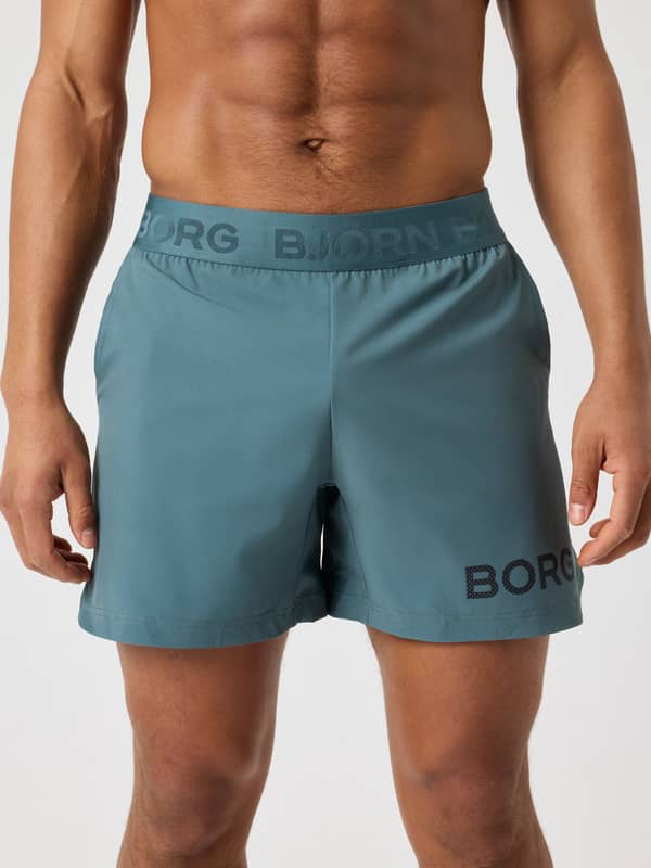 Front view of the Balsam Green (Green) Borg Shorts 6 Inch for training, featuring a branded waistband and dark logo.