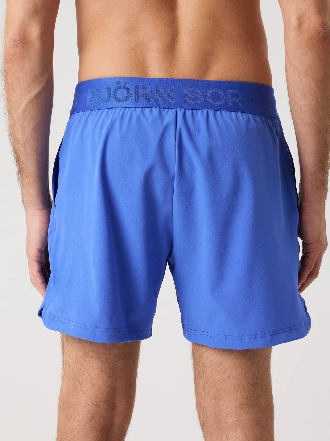 Back view of a man in Amparo Blue (Blue) Borg Shorts 6 Inch with tonal logo, for style, performance, training and tennis. - Image 2
