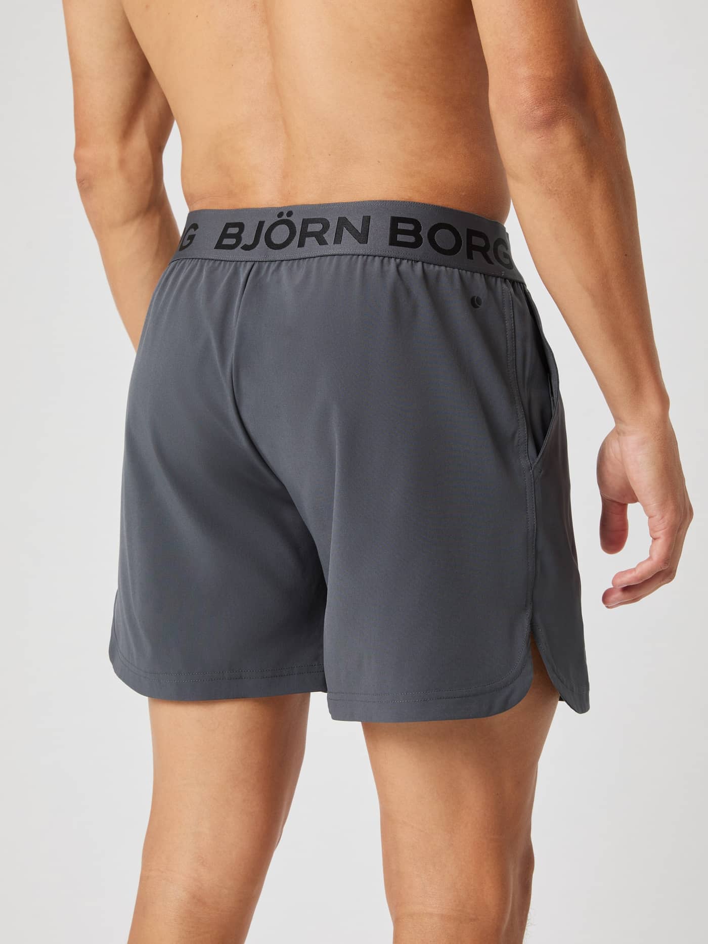 Back view of a model wearing the Borg 6" Shorts in asphalt grey, showing the branded elastic waistband and side slit. - Image 3
