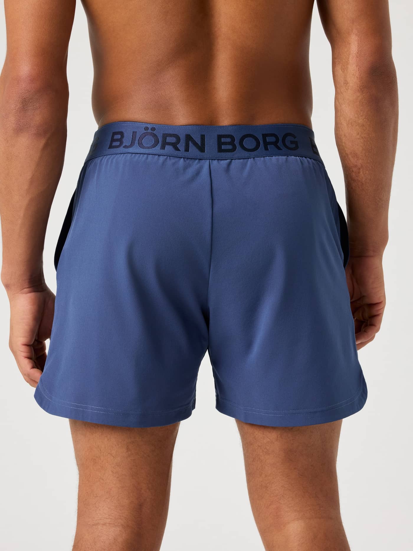 Back of a model wearing the navy blue Björn Borg Borg 6-inch shorts, showing the logo waistband. - Image 2