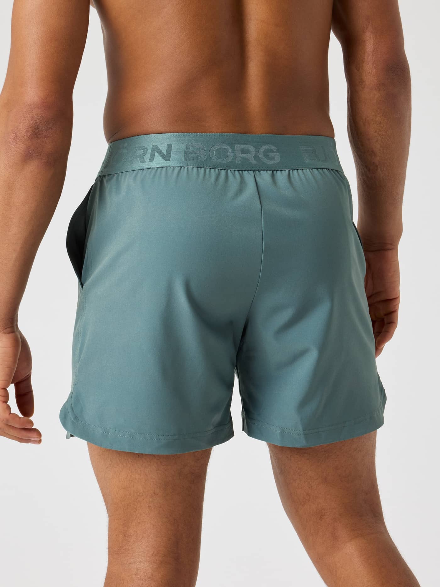 Back view of a man wearing the Björn Borg Shorts 6 Inch in Balsam Green (Green) with a tonal logo waistband for training. - Image 2
