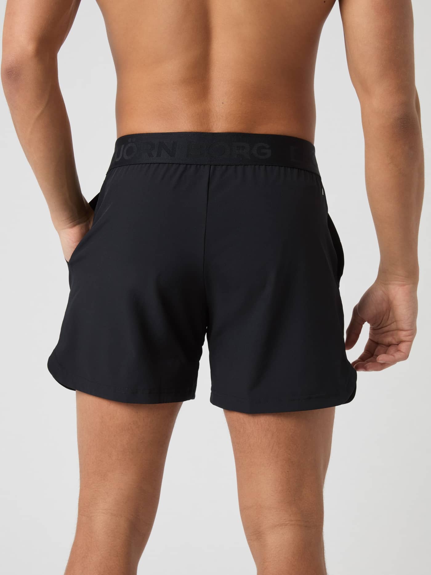 Vue de dos d'un mannequin en Borg Shorts 6 Inch Black Beauty (Noir) avec ceinture marquée pour l'entraînement. - Image 2