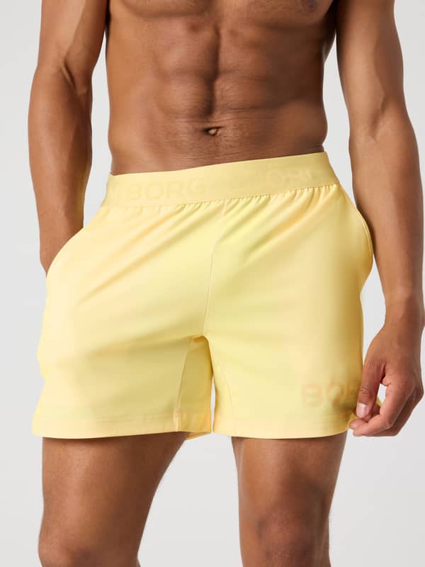 Vue de face d'un homme en Borg Shorts 6 Inch Lemonade (Jaune), tissu extensible pour la performance d'entraînement.