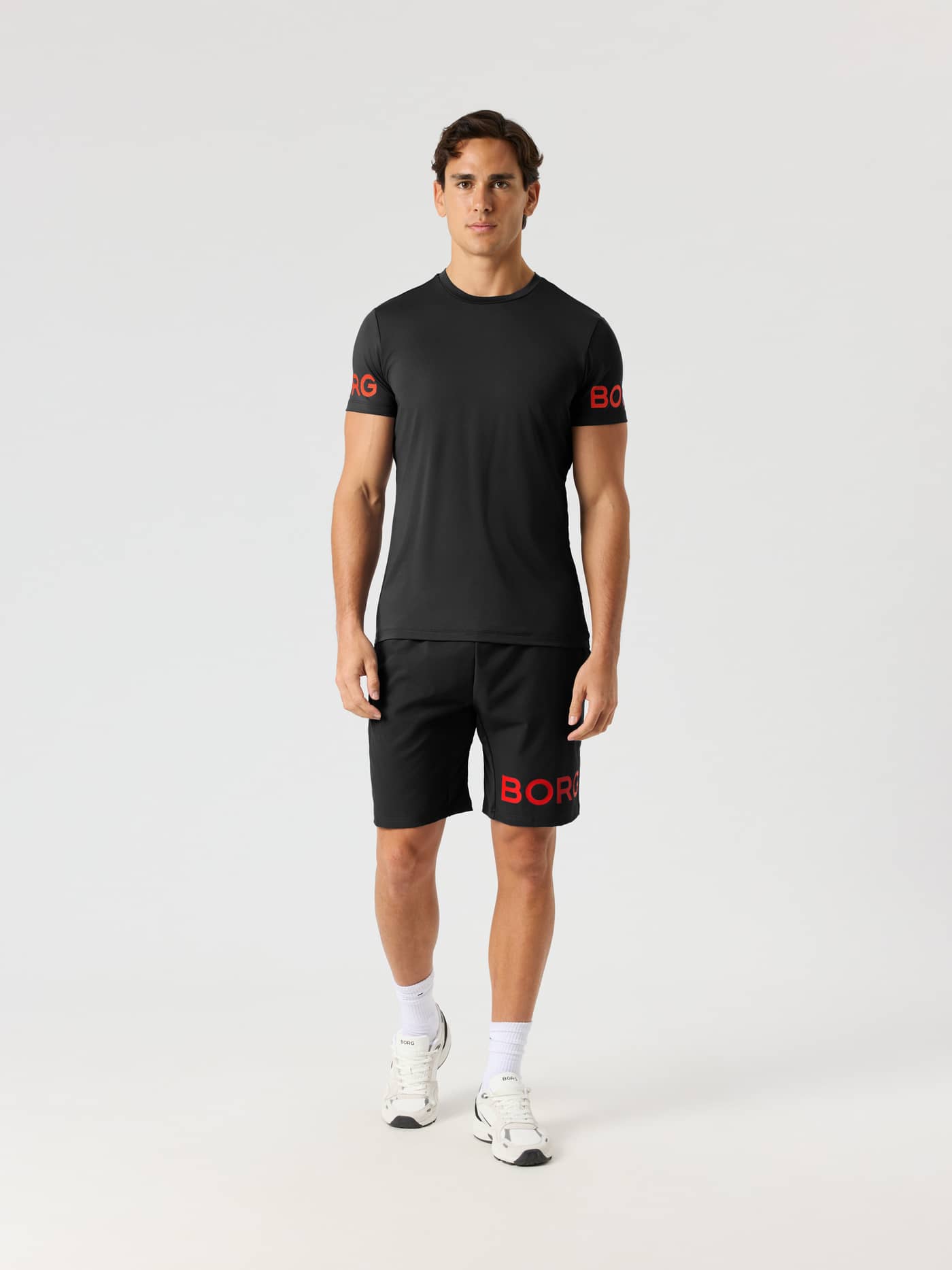 Vue de face d'un modèle en Borg T-Shirt Black Orange Logo (Noir), un haut de training technique pour homme. - Image 4