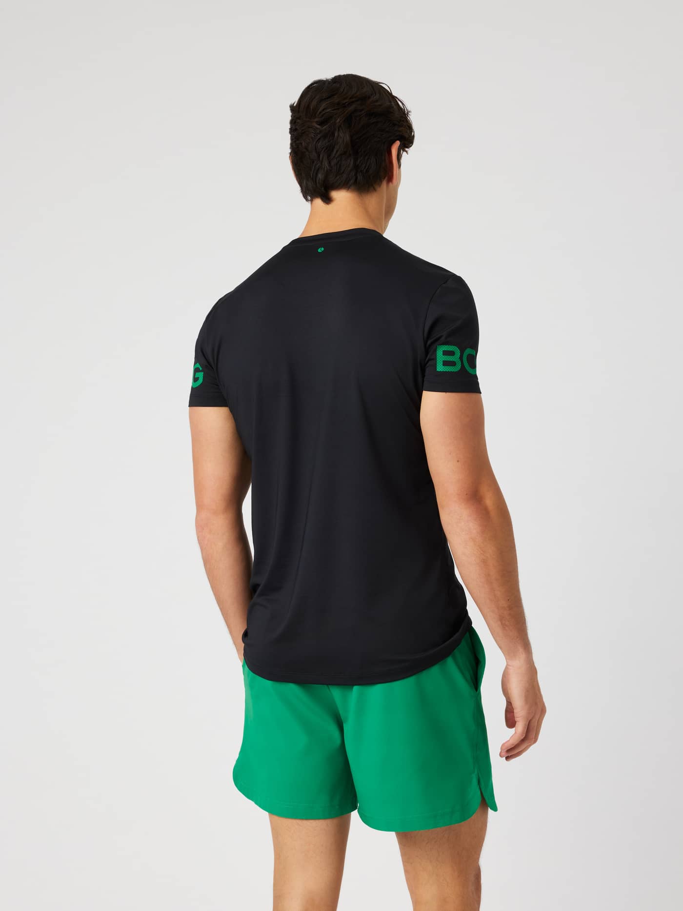 Borg T-Shirt i Black Beauty (sort) set bagfra med grønne logoprint på armene til træning. - Image 3