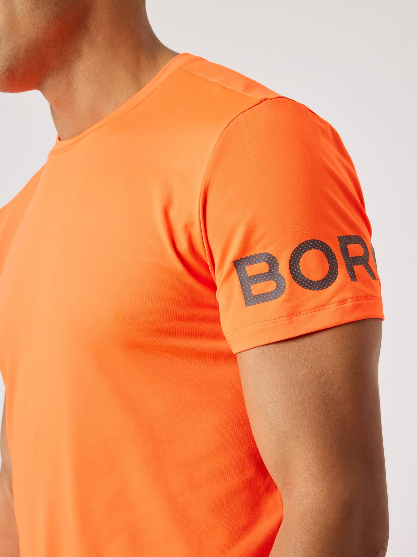 Borg T-Shirt i Shocking Orange (Orange) set fra siden med et mørkt logo på ærmet til træning. - Image 4