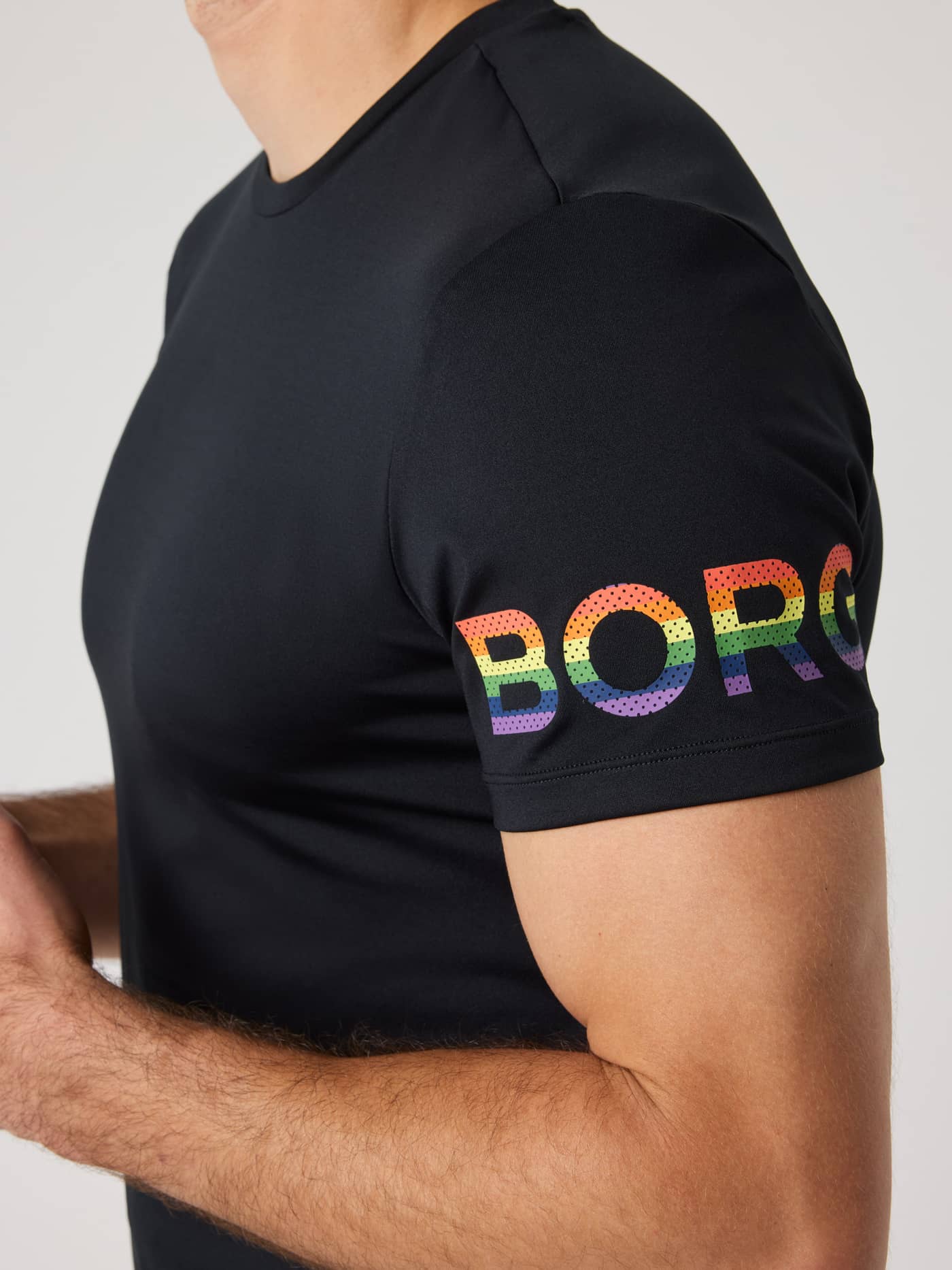 Nahaufnahme eines Mannes im Borg T-Shirt in Black Beauty (Schwarz) für das Training mit Regenbogen-Logo am Ärmel. - Image 6
