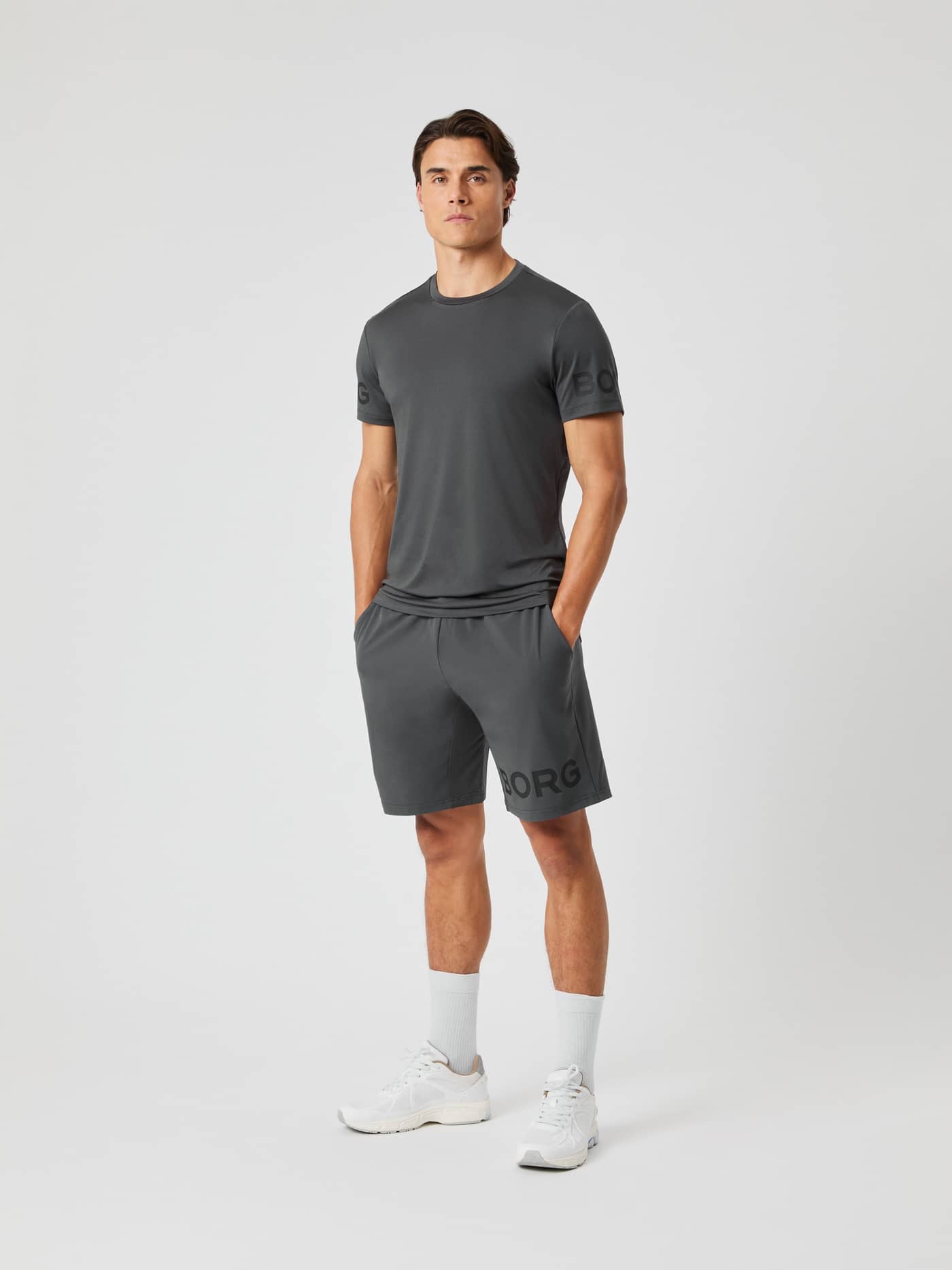 Full-length view of a man wearing the asphalt grey Borg T-shirt and matching shorts against a light grey background. - Image 3