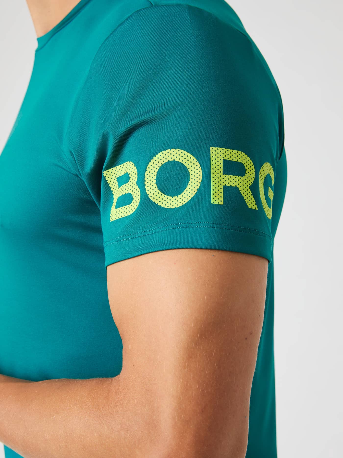 Close-up of the sleeve of the Shaded Spruce Borg T-shirt, showing the bright green BORG logo. - Image 3