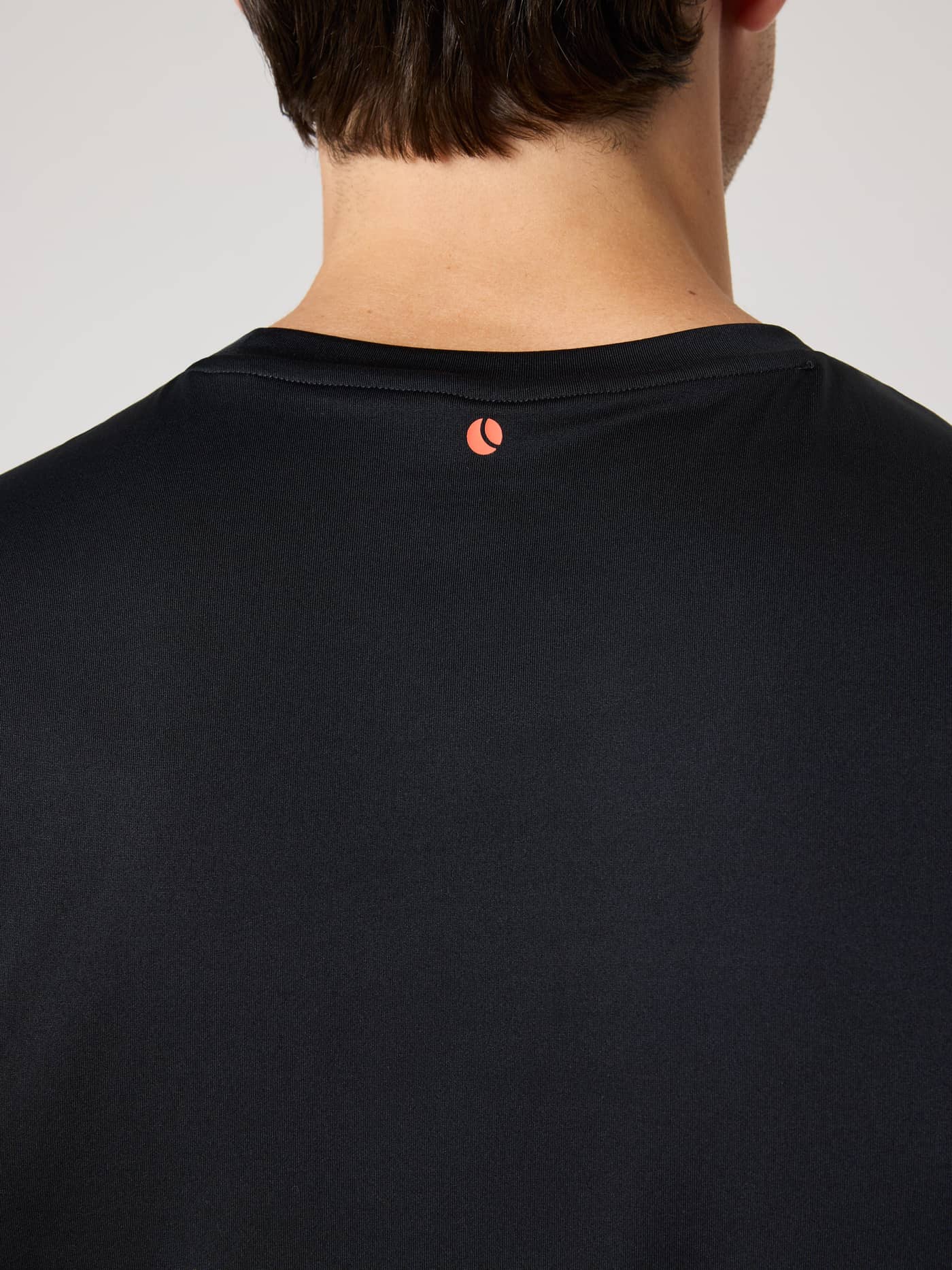 Rückansicht des Borg T-Shirt in Black Beauty (Schwarz) für das Training mit einem orangen Tennisball-Logo. - Image 7