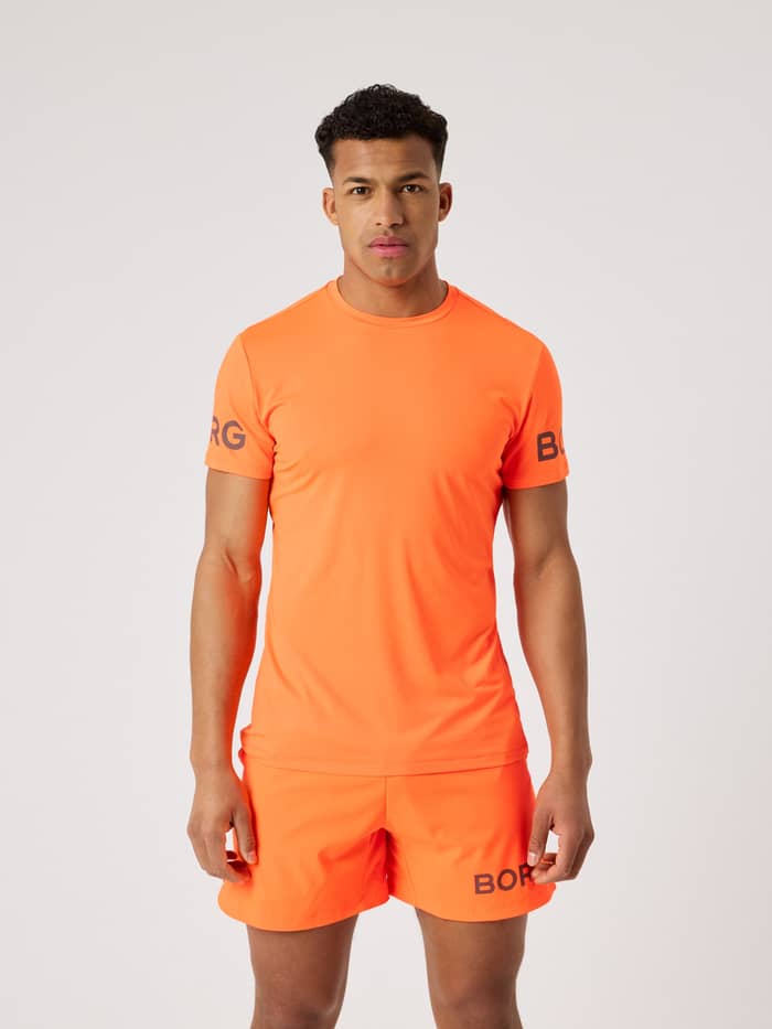 Front view of a man wearing the Björn Borg T-Shirt in Shocking Orange (Orange) for performance training.