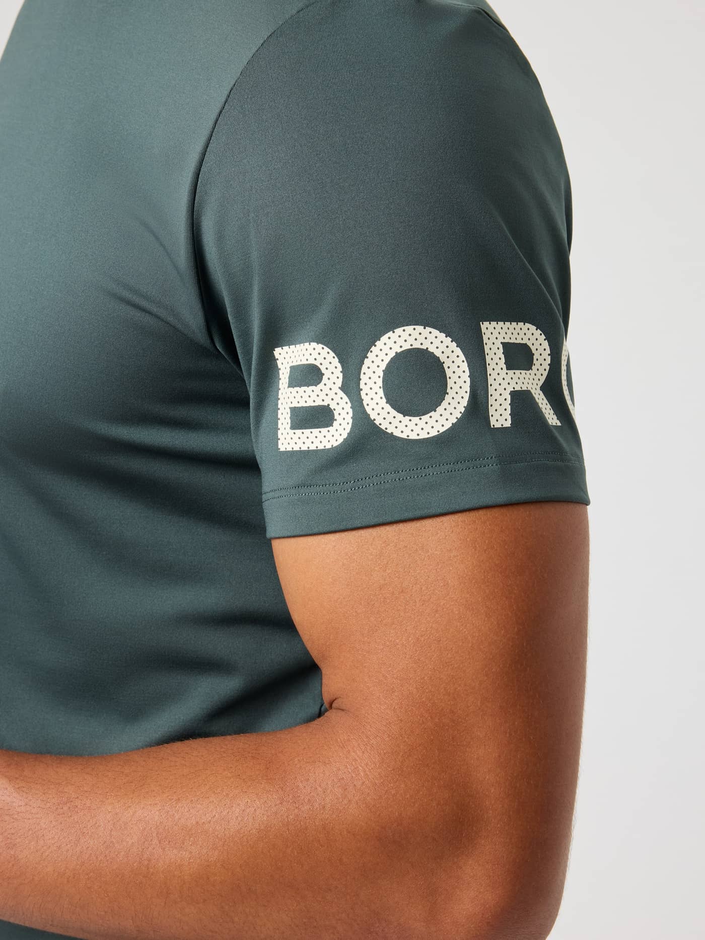 Borg T-Shirt i Urban Chic (Grøn) set i nærbillede med hvidt perforeret logo på ærmet til træning. - Image 5