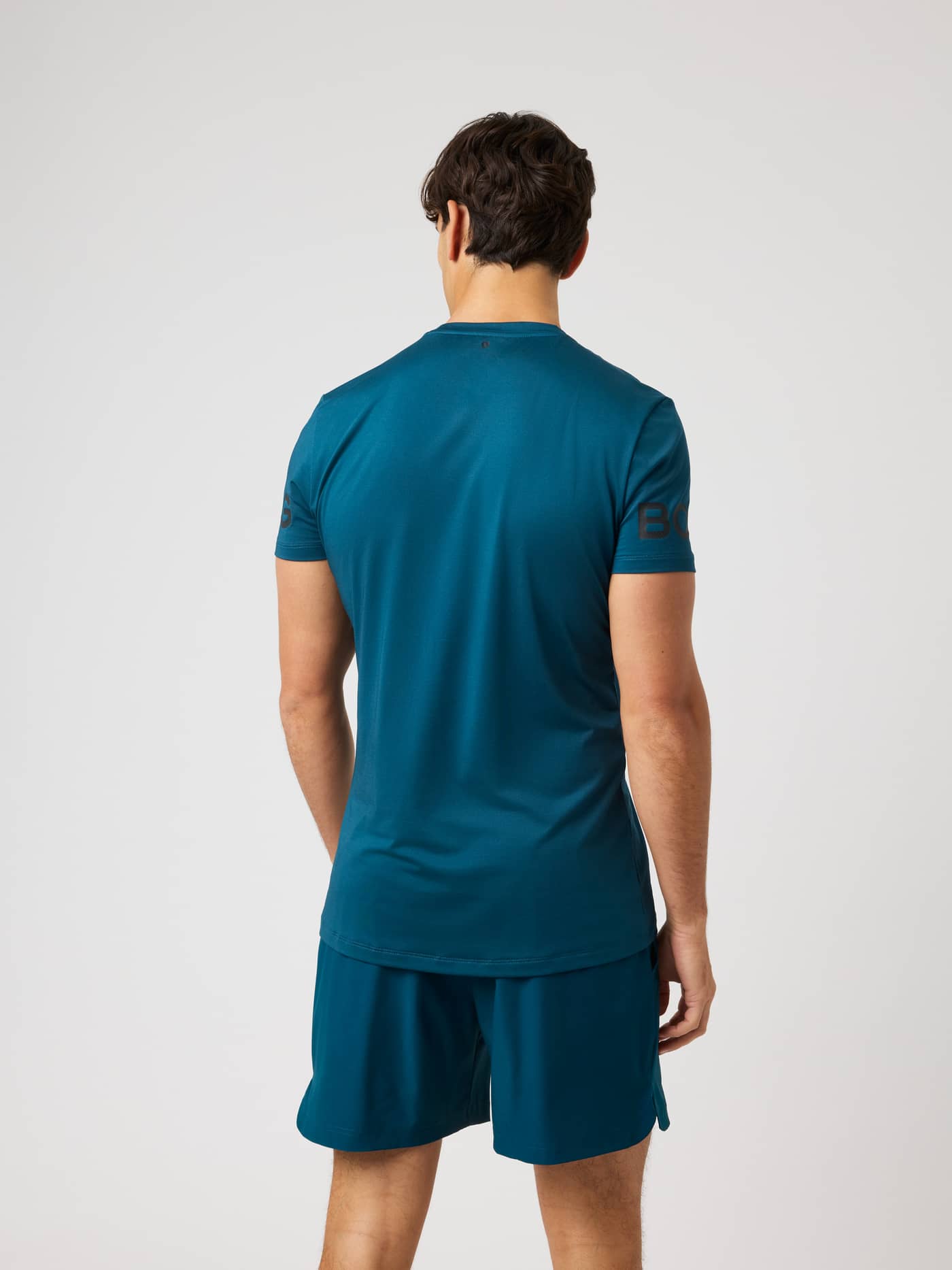 Back view of the Borg T-Shirt in Reflecting Pond (Green), a training staple with a dark perforated sleeve logo. - Image 3