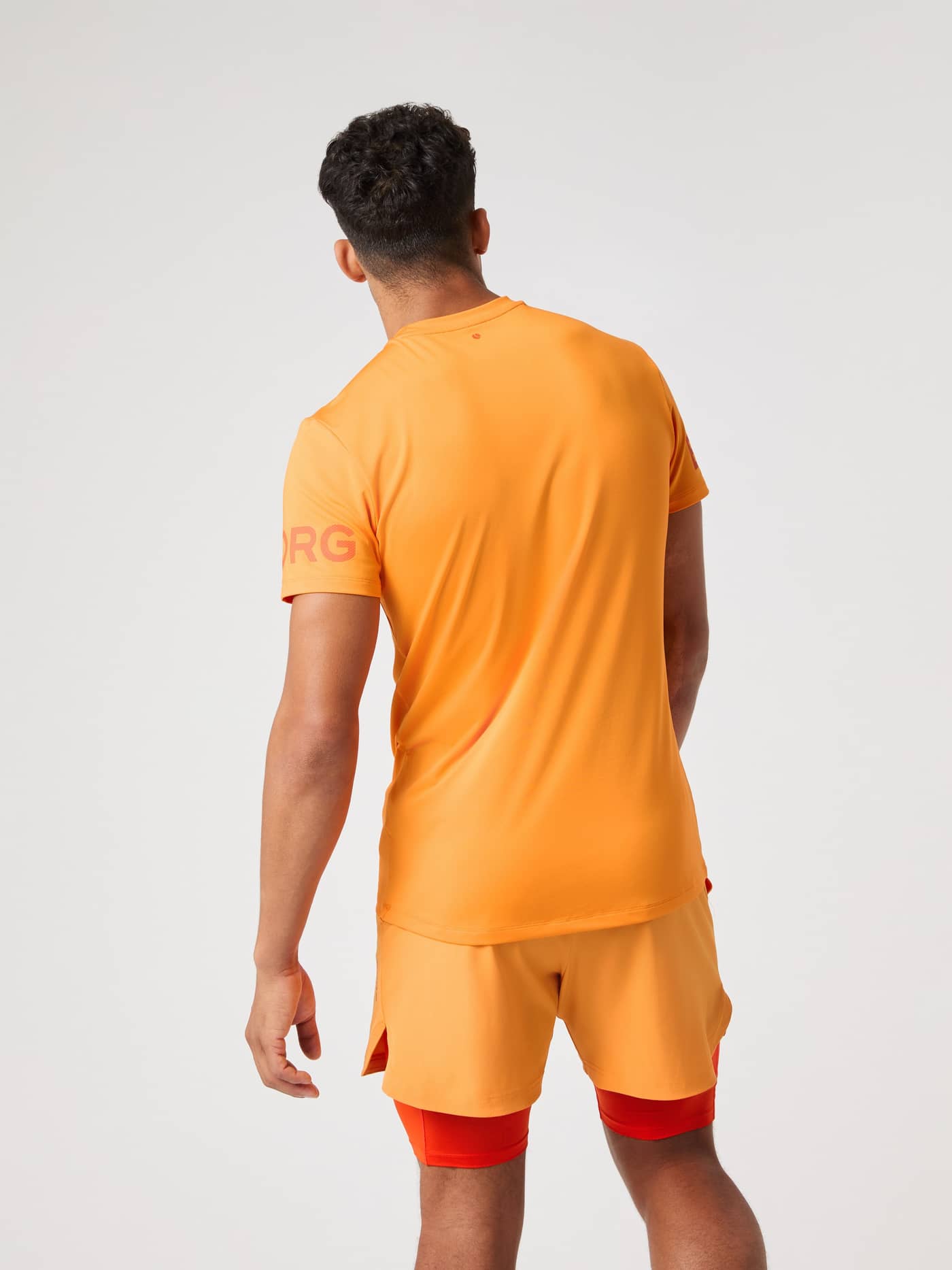 Borg T-Shirt i Sun Orange (Orange) set bagfra med logo på ærmerne til performance og træning. - Image 2