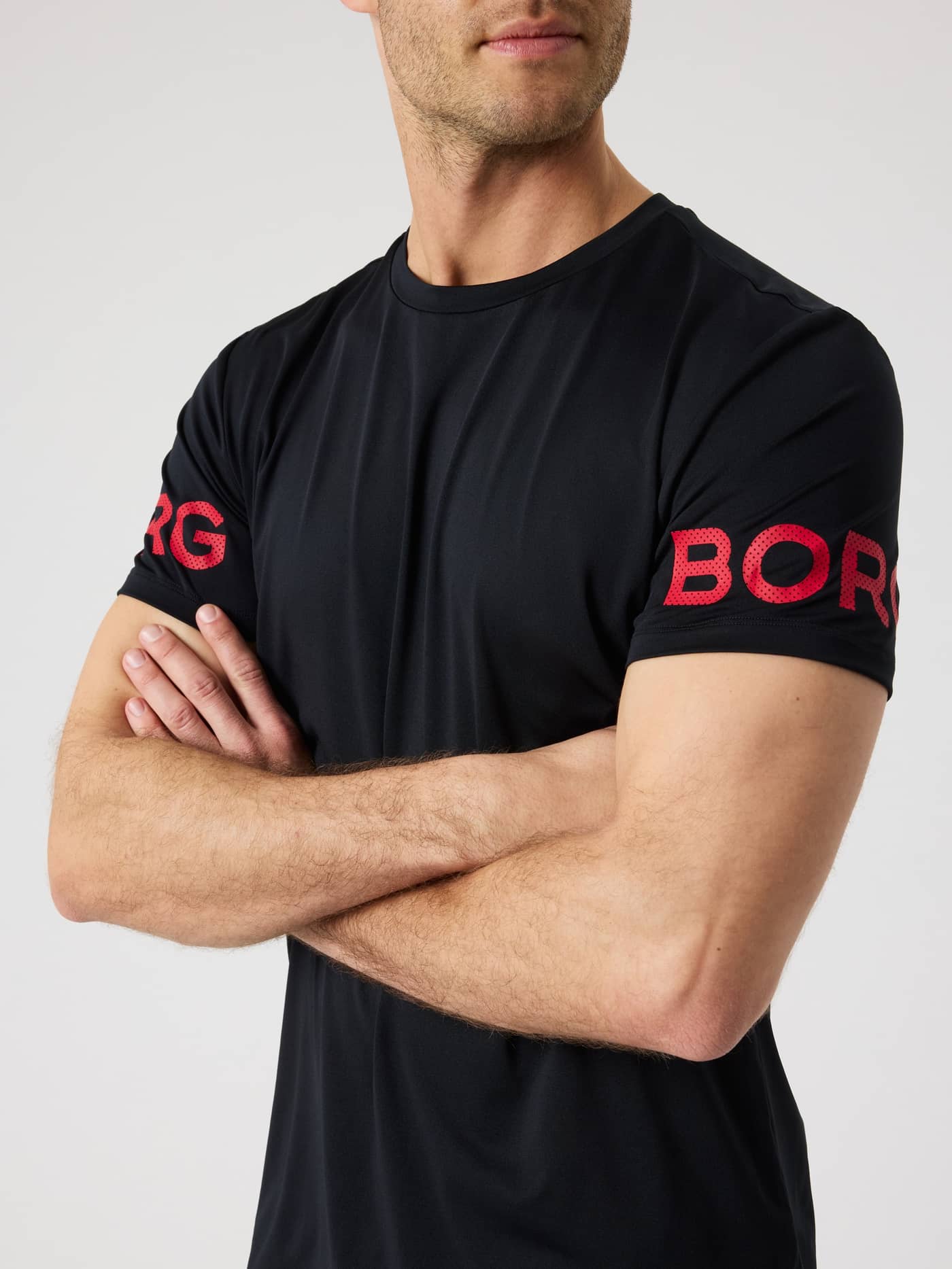 Borg T-Shirt i Black Beauty (Sort) set forfra på mand med korslagte arme til træning og tennis med røde logoer. - Image 5