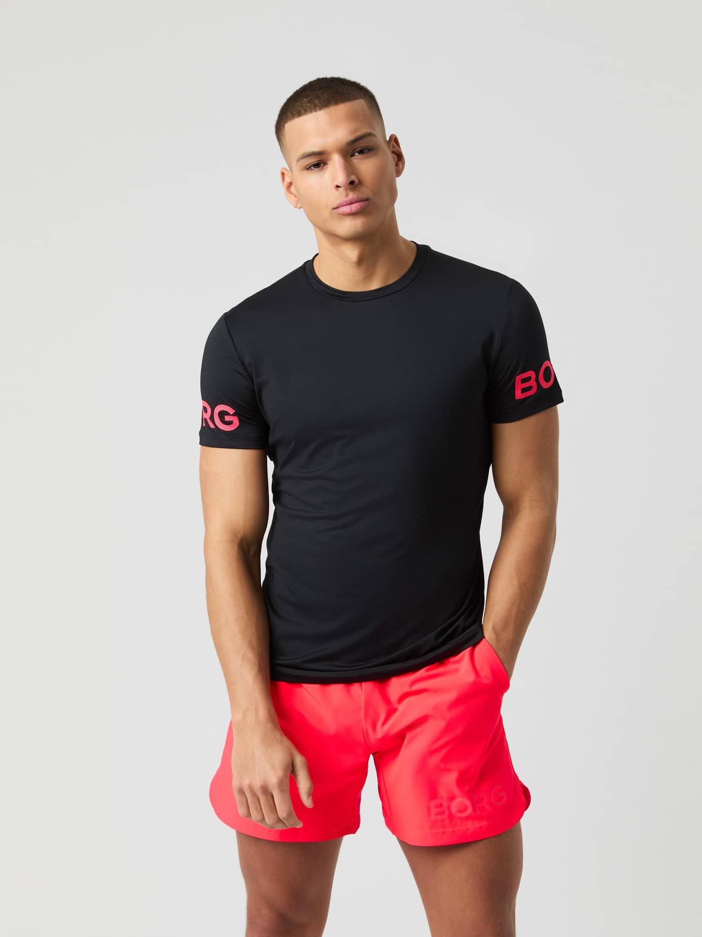 Model seen from the front wearing the black Björn Borg Borg T-shirt with pink logo details on the sleeves. - Image 1