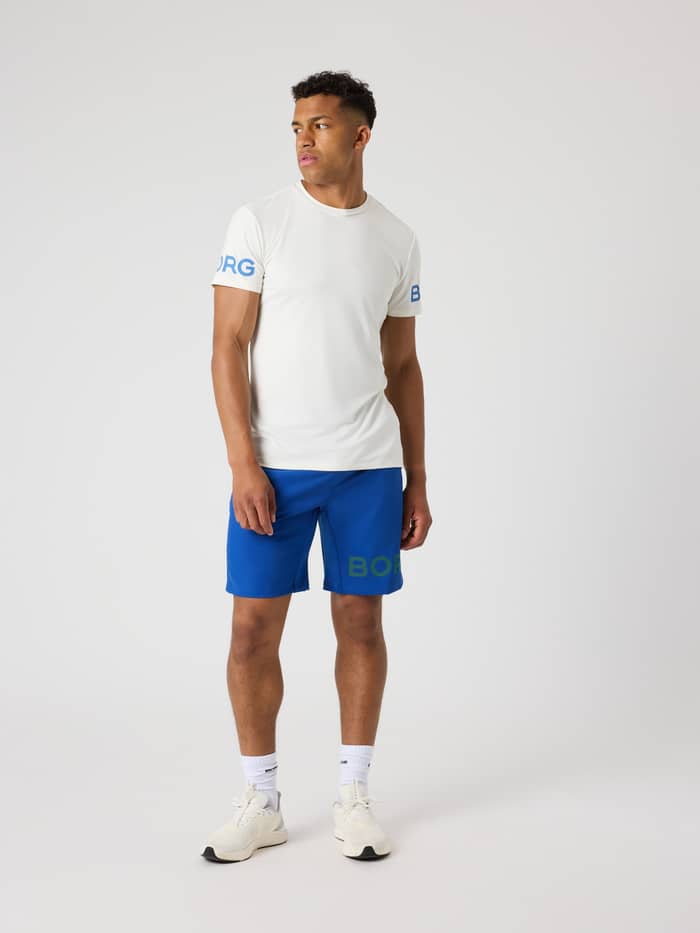 Borg T-Shirt i Tofu (Hvid) set forfra i fuld figur med blå logoer på ærmerne til performance og træning. - Image 3