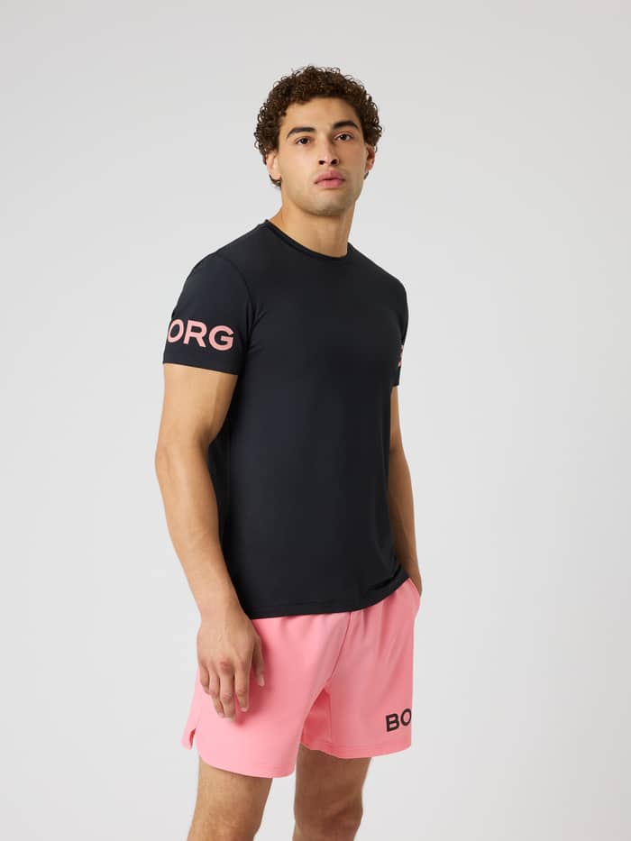 Vue de face d'un modèle en Borg T-Shirt Black Pink Logo (Noir) avec logos roses pour le training et le tennis. - Image 2