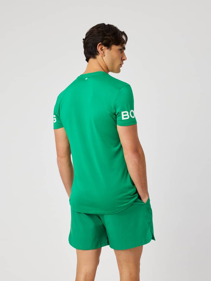 Back view of a man wearing the Borg T-Shirt in Jolly Green (green) for training, highlighting the white logo on the arms.