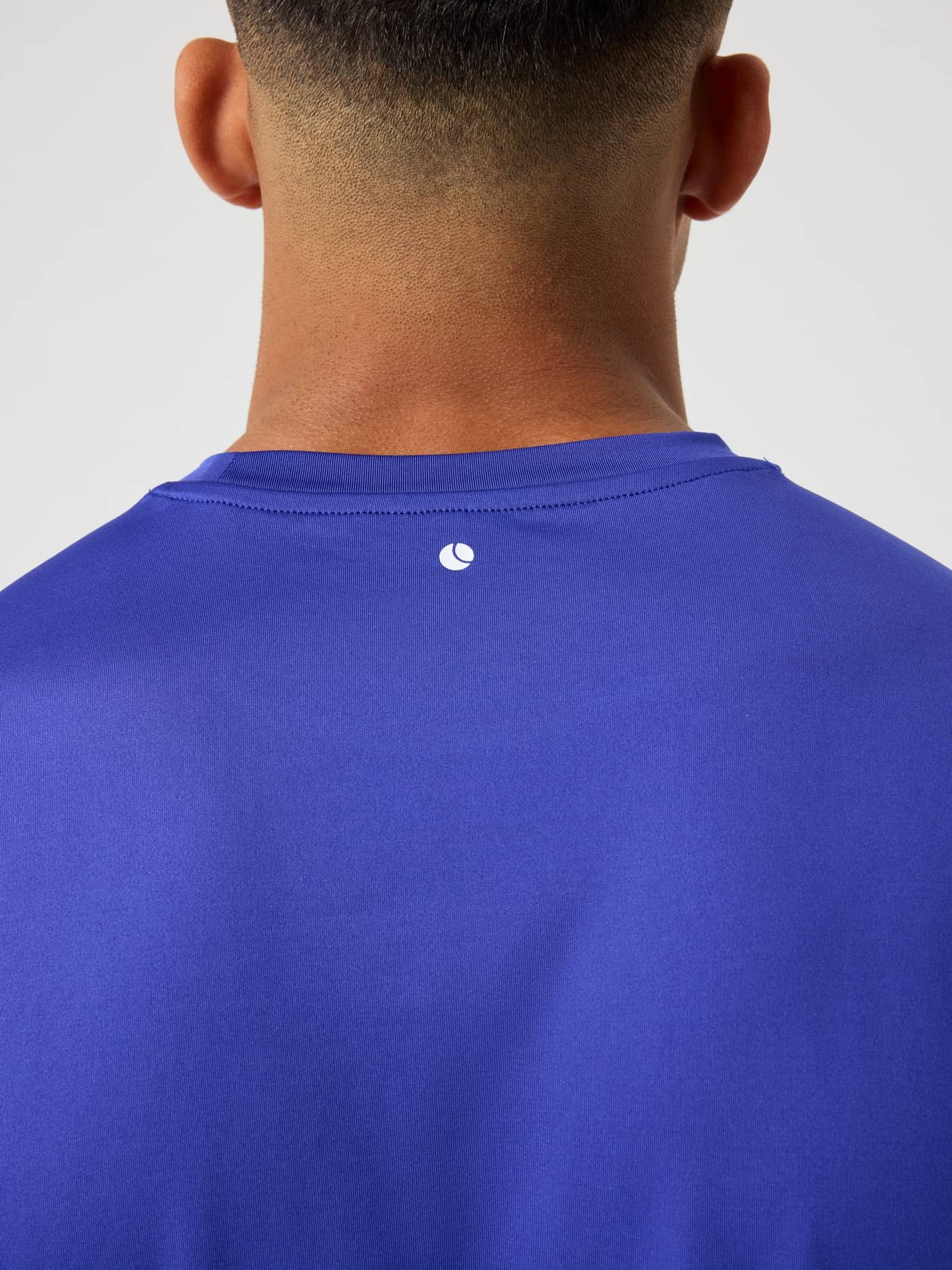 Nærbilde bakfra av Borg T-Shirt til trening i Clematis Blue (Blå) med en hvit tennisball-logo i nakken. - Image 5